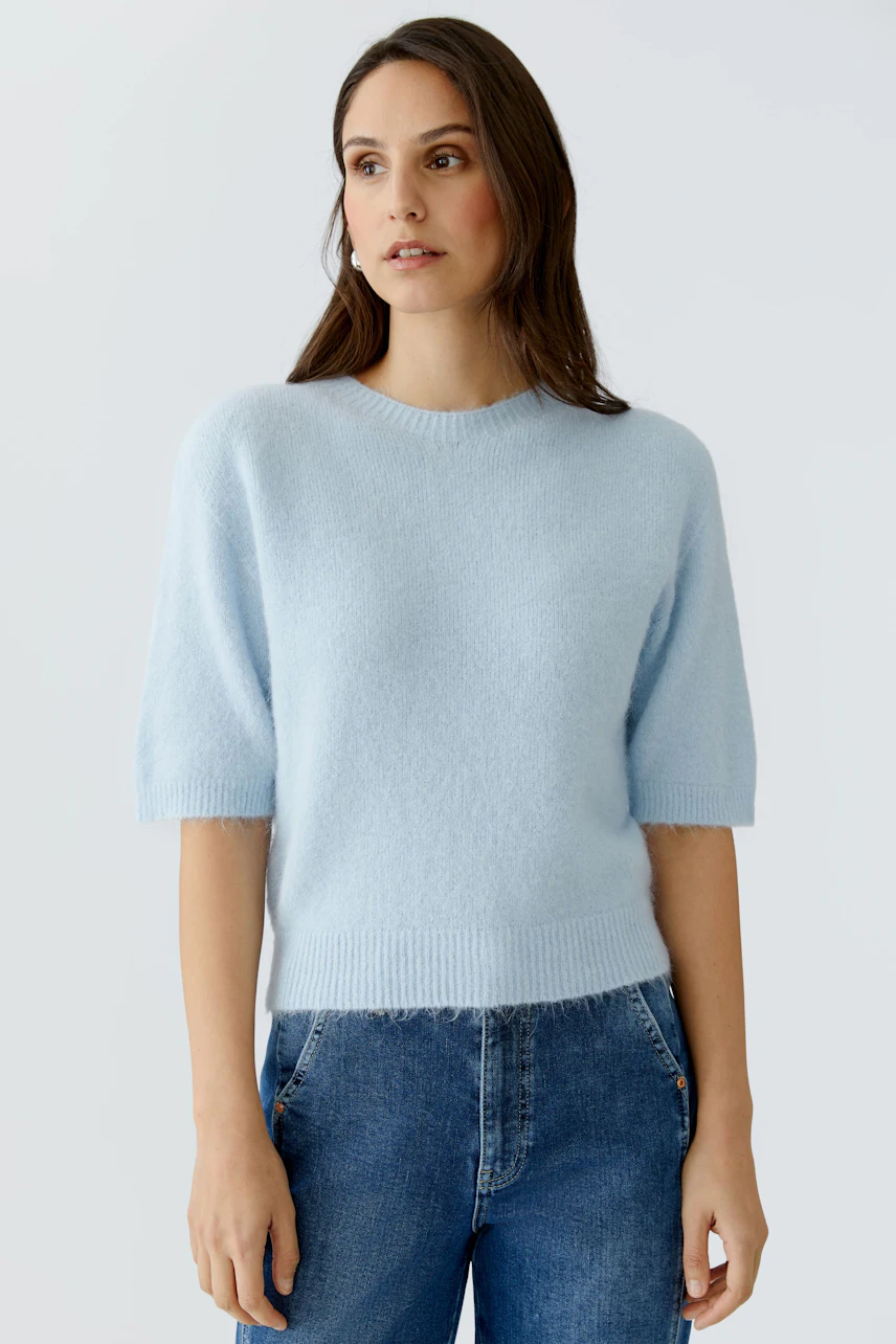 Leichter Damen-Pullover in Hellblau mit kurzen Ärmeln, kombiniert mit lässigen Jeans.