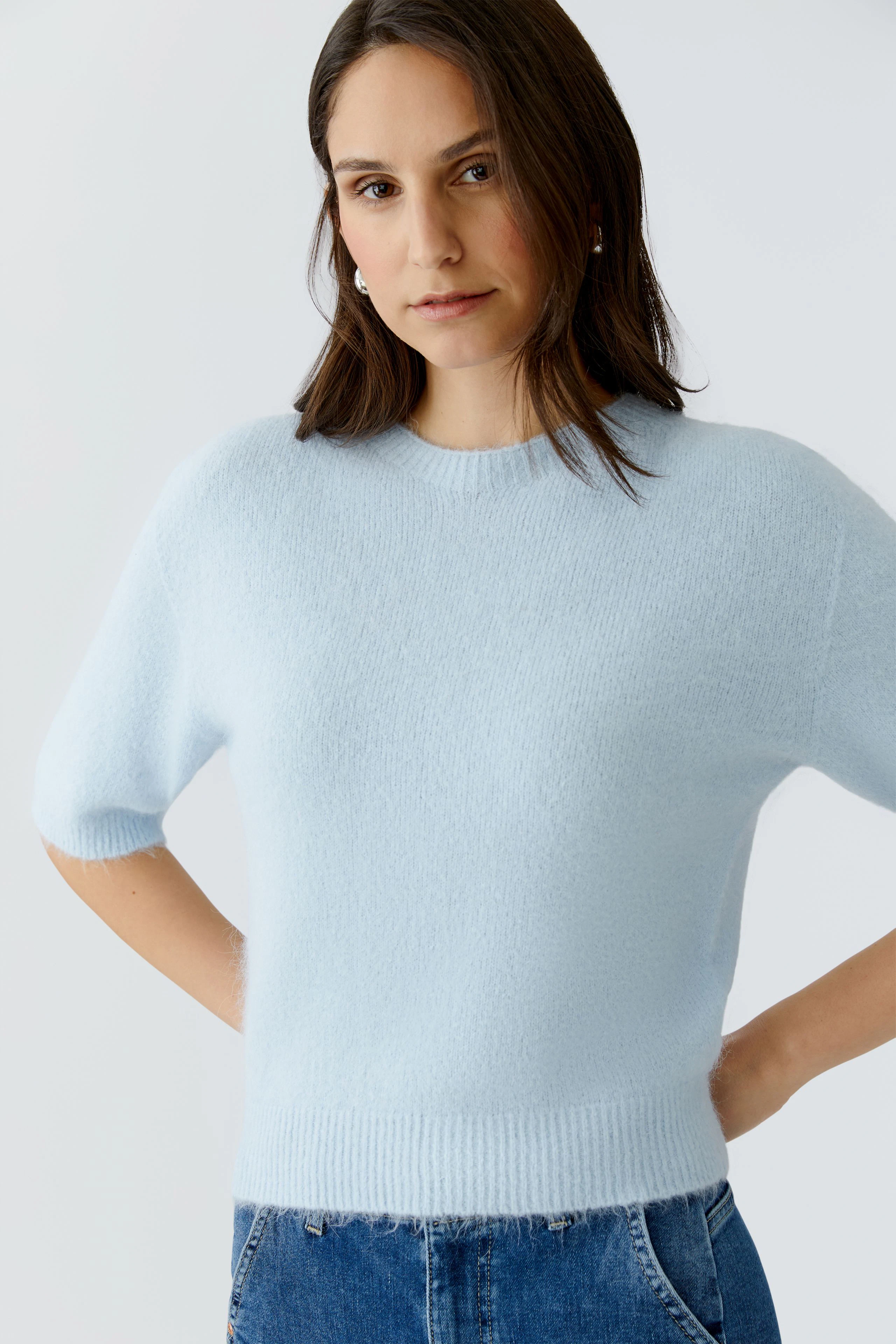 Helle Damen-Pullover: Frau trägt einen blauen, lässigen Pullover mit kurzen Ärmeln und Rundhalsausschnitt.