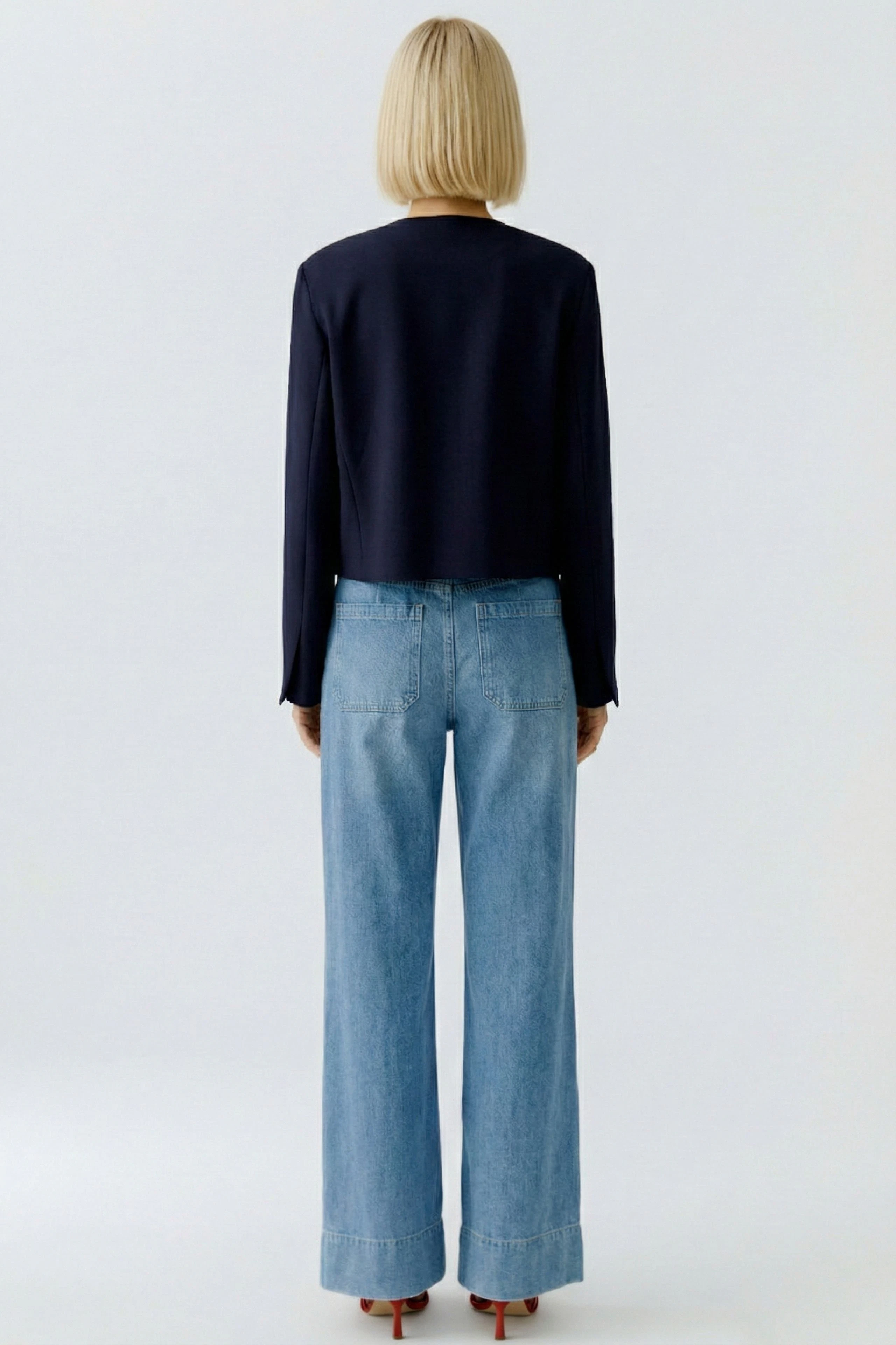 Casual women's jacket: A woman in a navy jacket paired with wide-leg jeans, showcasing a relaxed style.