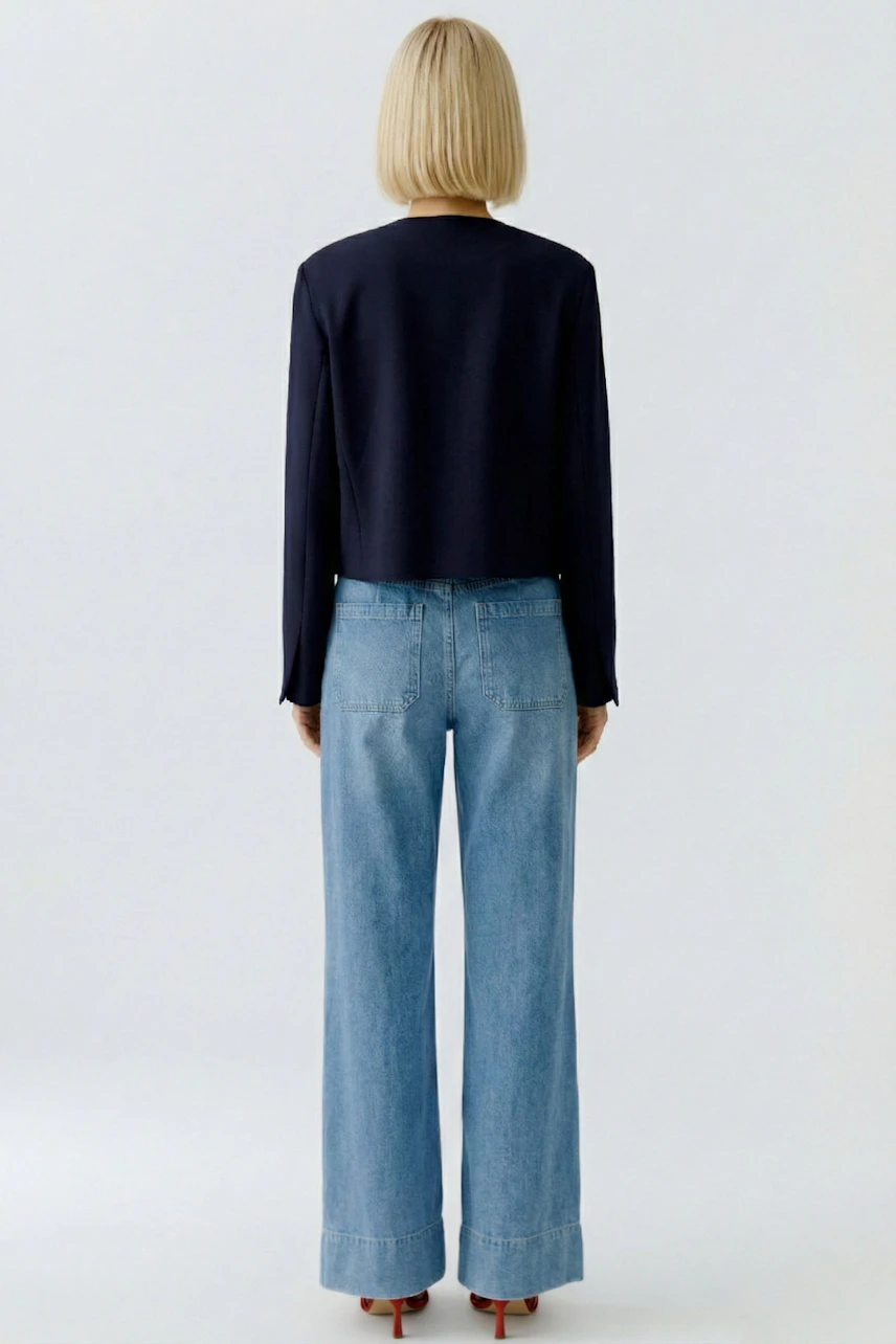 Casual women's jacket: A woman in a navy jacket paired with wide-leg jeans, showcasing a relaxed style.