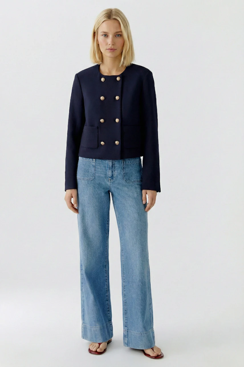 Casual women's jacket: A woman in a navy jacket with gold buttons and pockets, paired with wide-leg jeans.