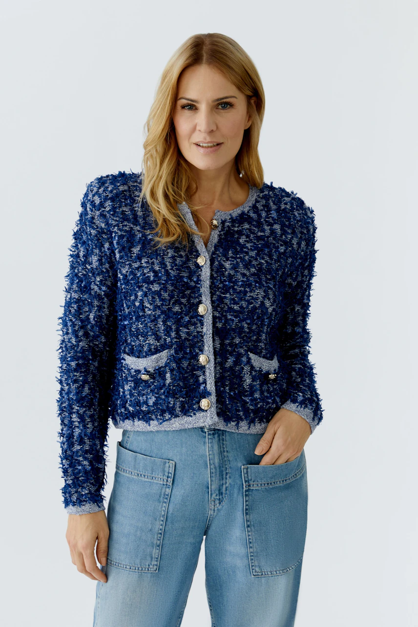 Casual women's cardigan: A woman in a blue textured cardigan with pockets and buttons, paired with jeans.