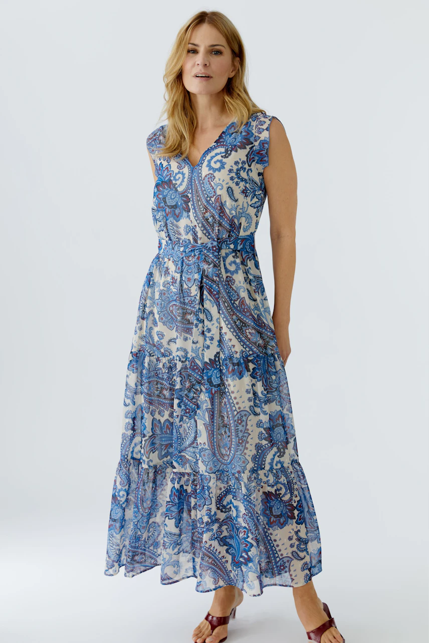 Maxi dress: Woman in a blue patterned maxi dress with a flowy silhouette and a relaxed fit.
