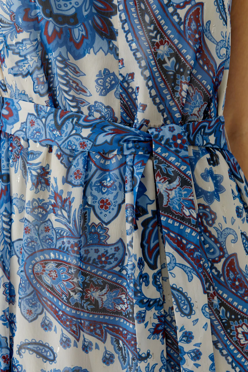Maxi dress: Close-up of a woman wearing a blue patterned maxi dress with a tied waist.