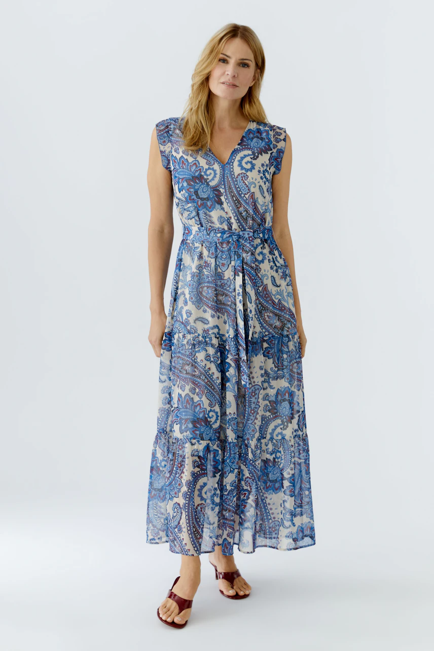 Maxi dress: Woman in a blue paisley print dress with a tie waist, perfect for warm days.