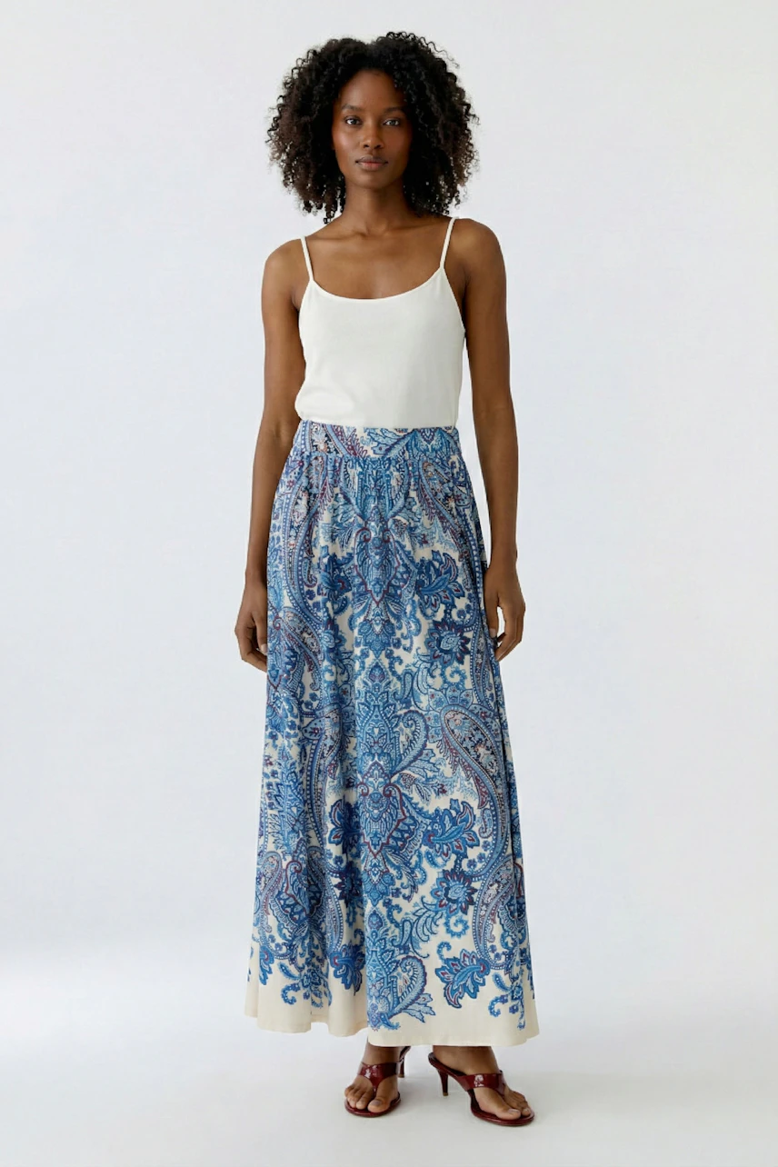 Flowy A-line skirt: Woman in a blue paisley print skirt, perfect for casual summer outings.