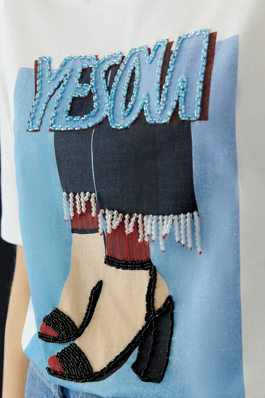 Casual women's T-shirt featuring a graphic print with stylish shoes and vibrant colors.