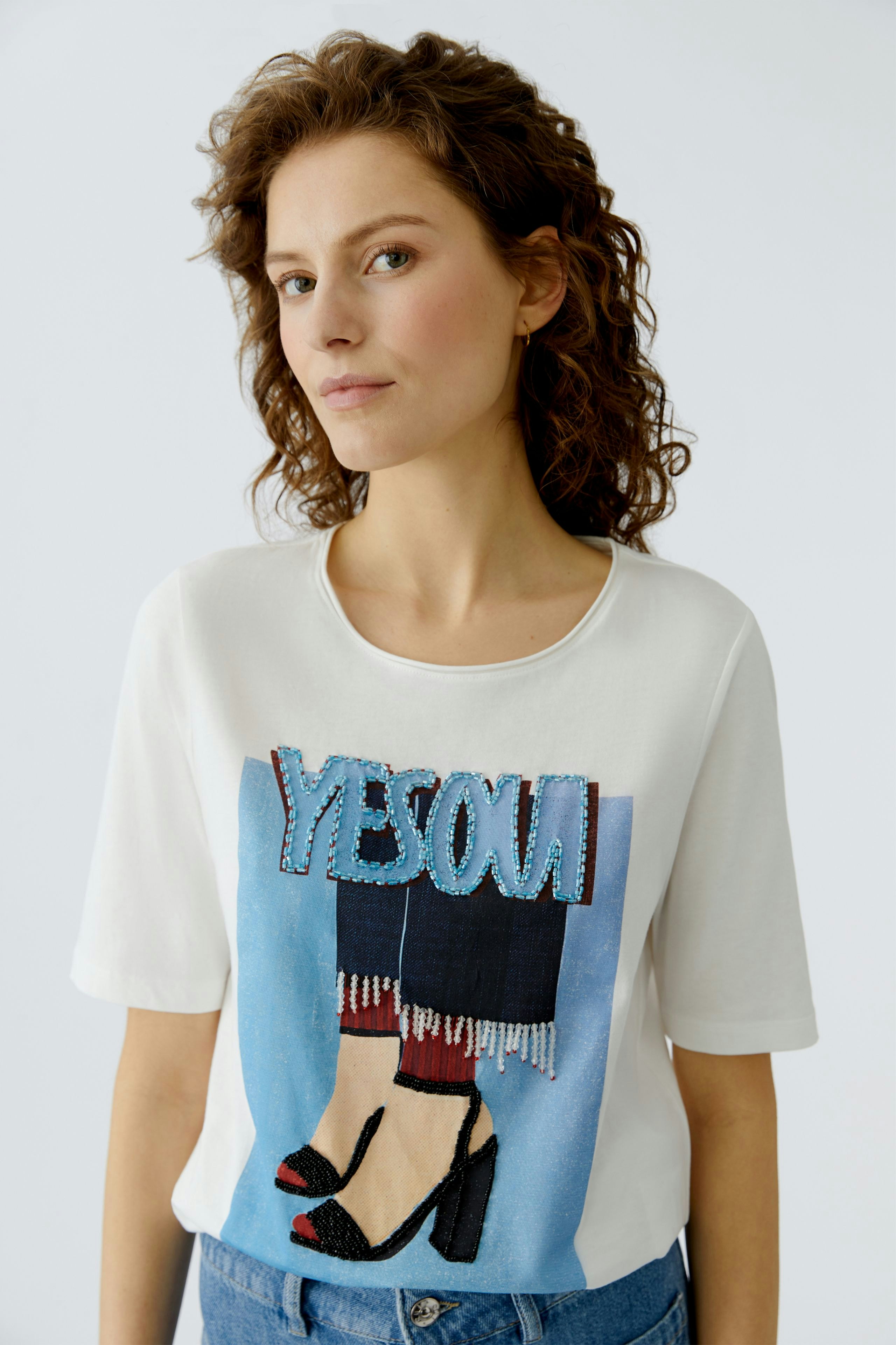 Casual women's T-shirt: Young woman in a white tee with a colorful graphic design and relaxed fit.