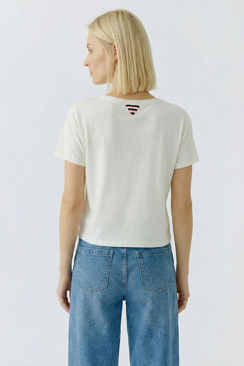 Casual women's T-shirt: A woman in a white T-shirt with a unique back design, paired with wide-leg jeans.