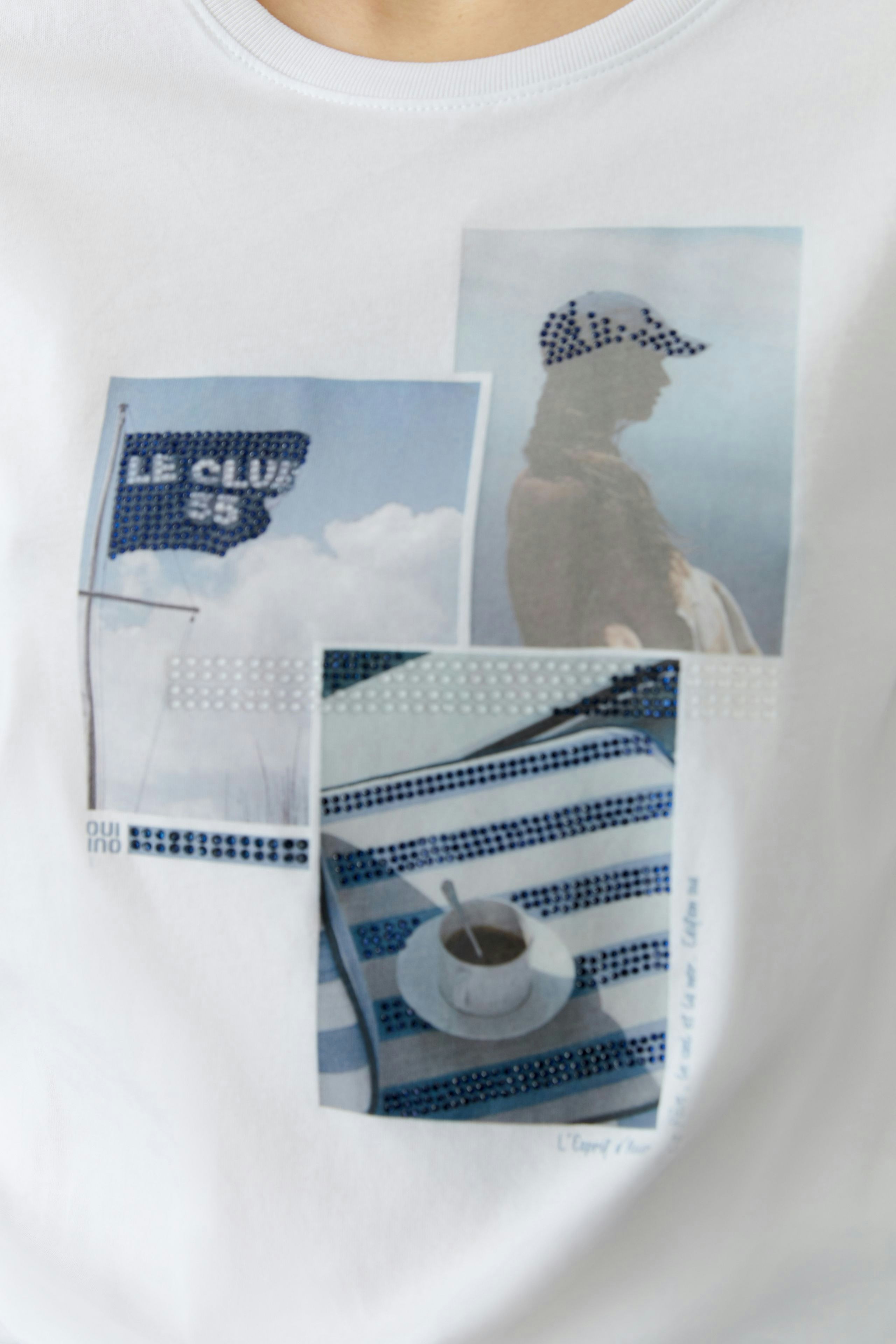 Casual women's T-shirt: Close-up of a white tee featuring a graphic print with beach and coffee motifs.