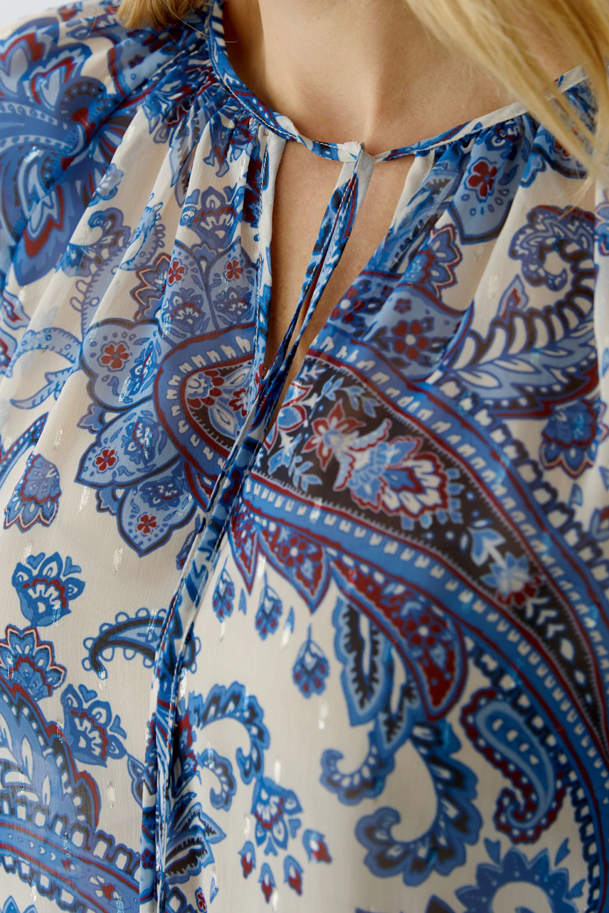 Lightweight blouse with a colorful paisley pattern, featuring a keyhole neckline and relaxed fit.