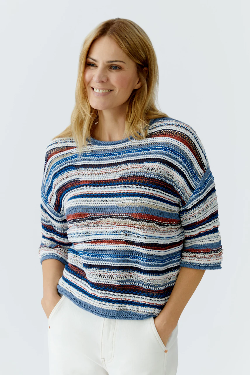 Casual women's pullover: Smiling woman in a striped knit pullover with relaxed fit.