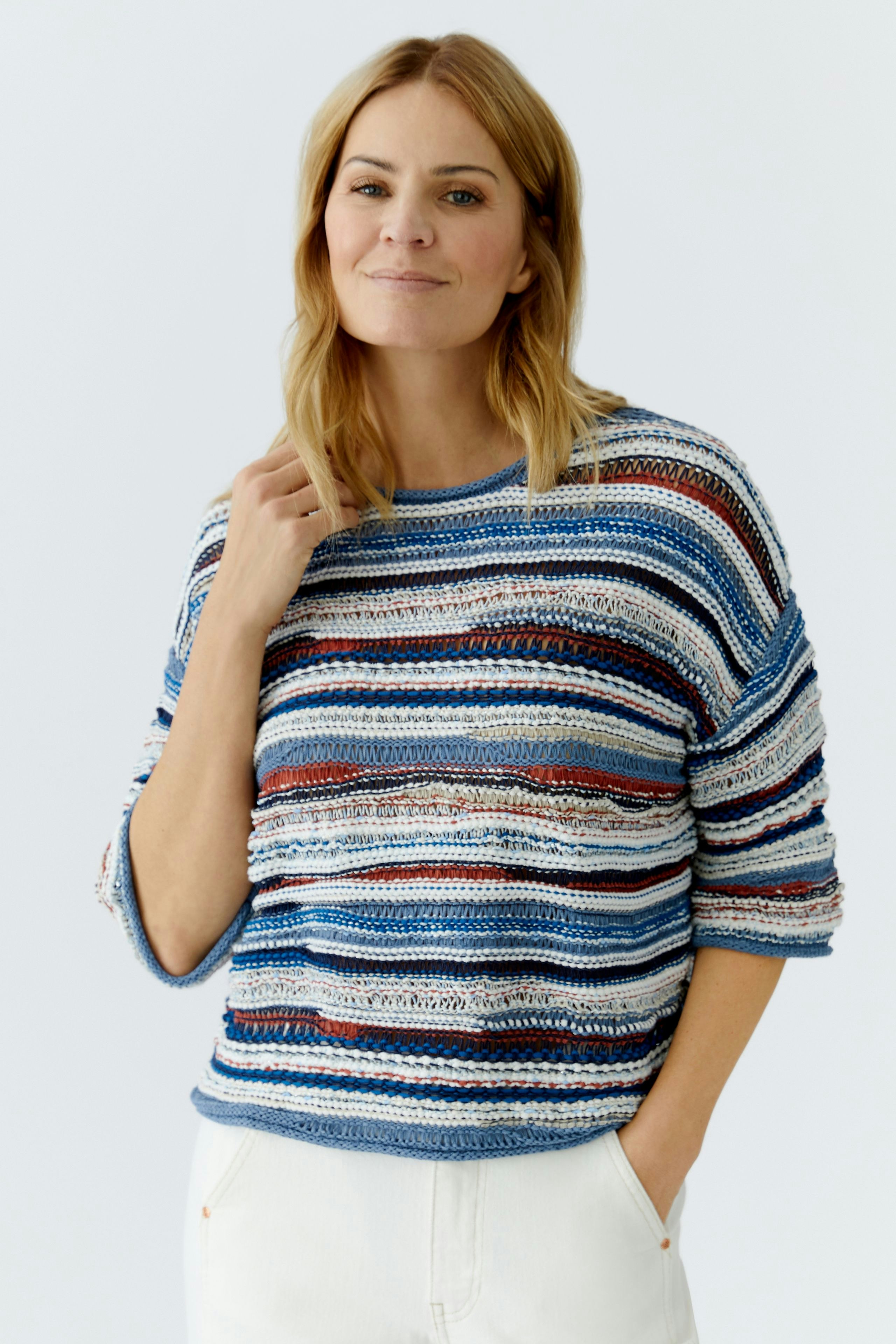 Lässiger Damen-Pullover: Frau in gestreiftem Pullover mit lockerer Passform und lässigem Look.