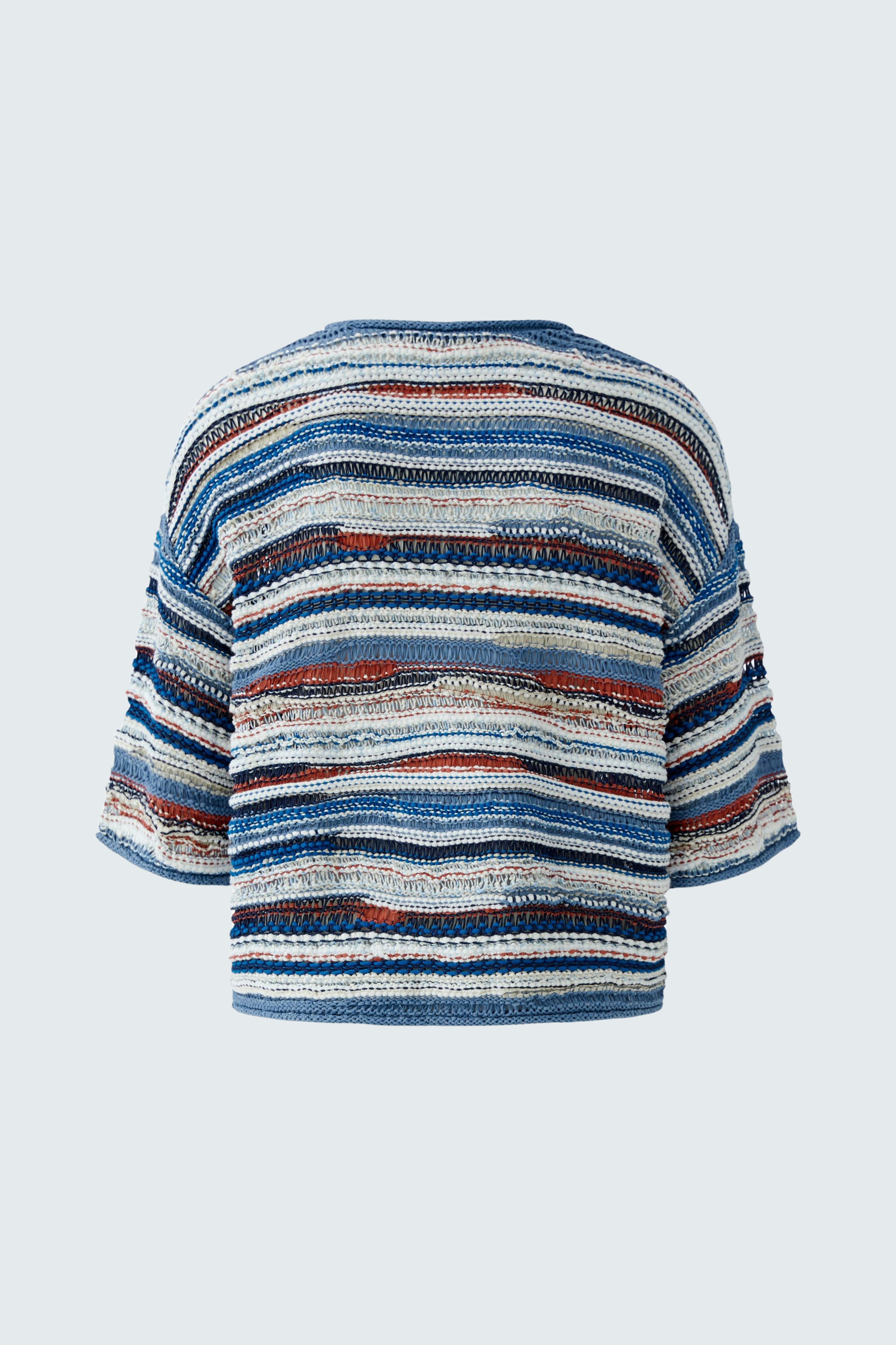 Casual women's pullover: A woman in a striped pullover with blue and red tones, showcasing a relaxed fit.