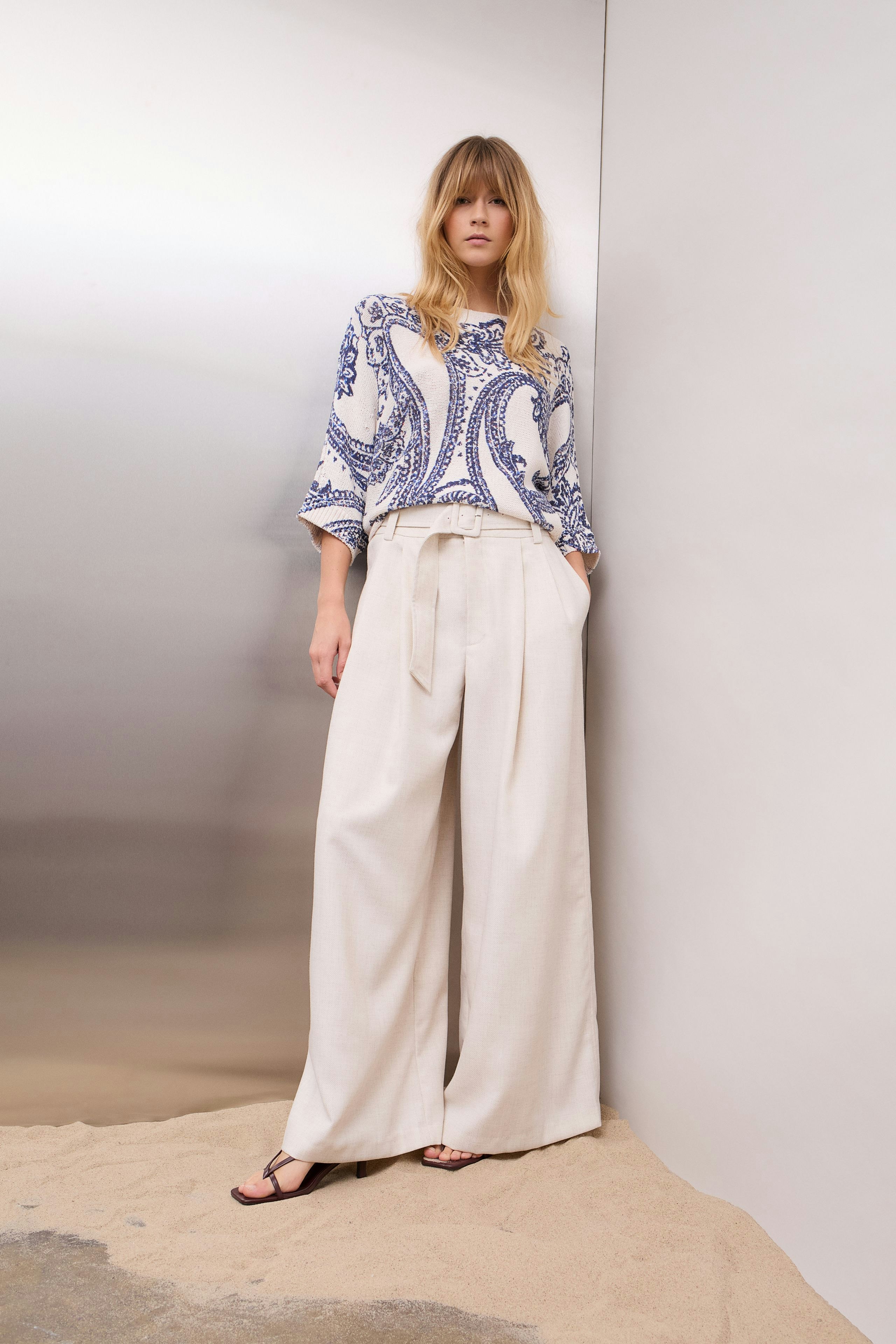 Casual women's pullover: A woman in a patterned pullover with wide sleeves stands confidently.