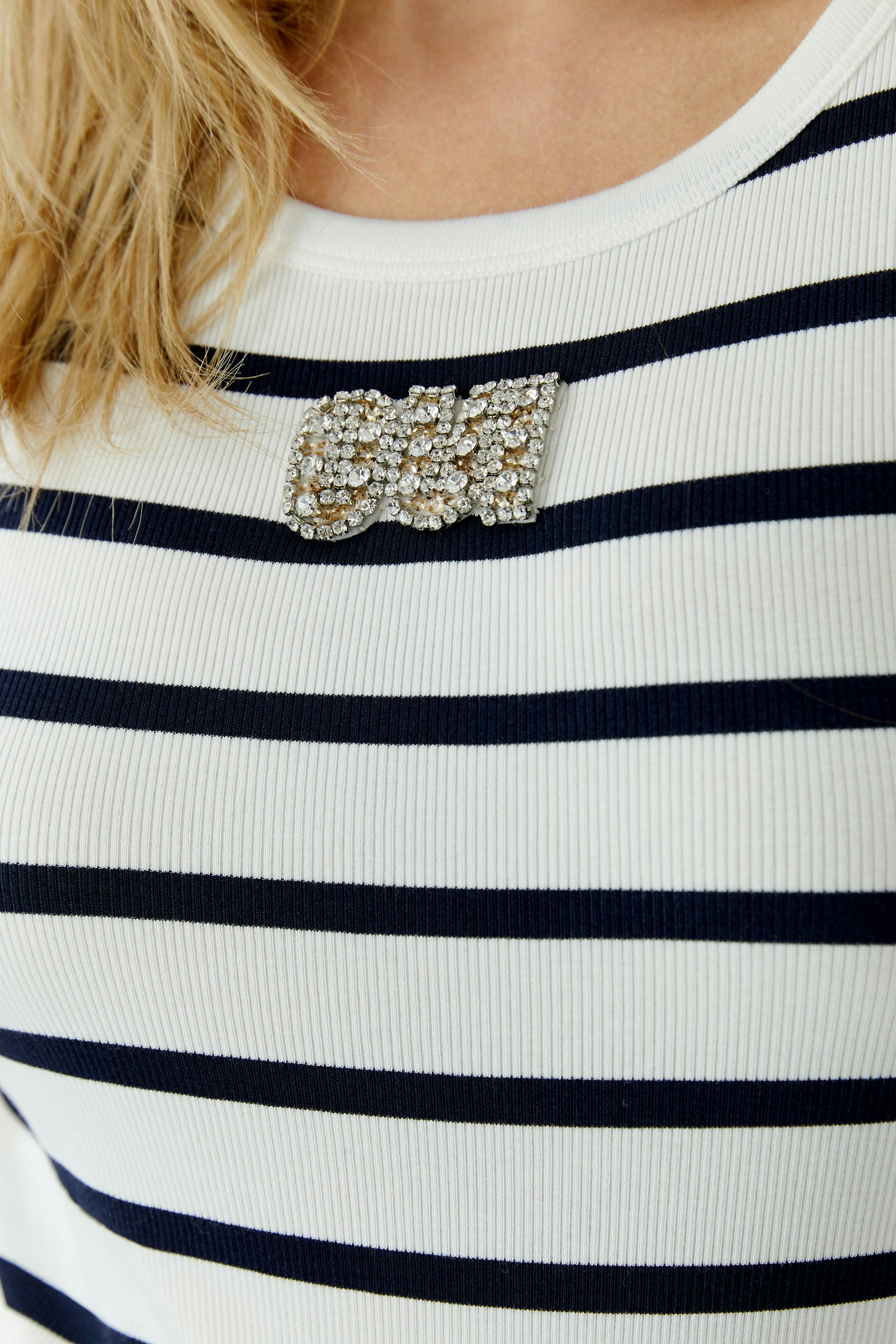 Casual women's tank top with navy stripes and a decorative brooch.