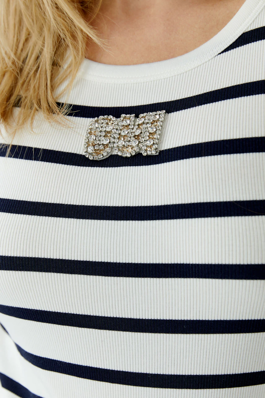 Casual women's tank top with navy stripes and a decorative brooch.