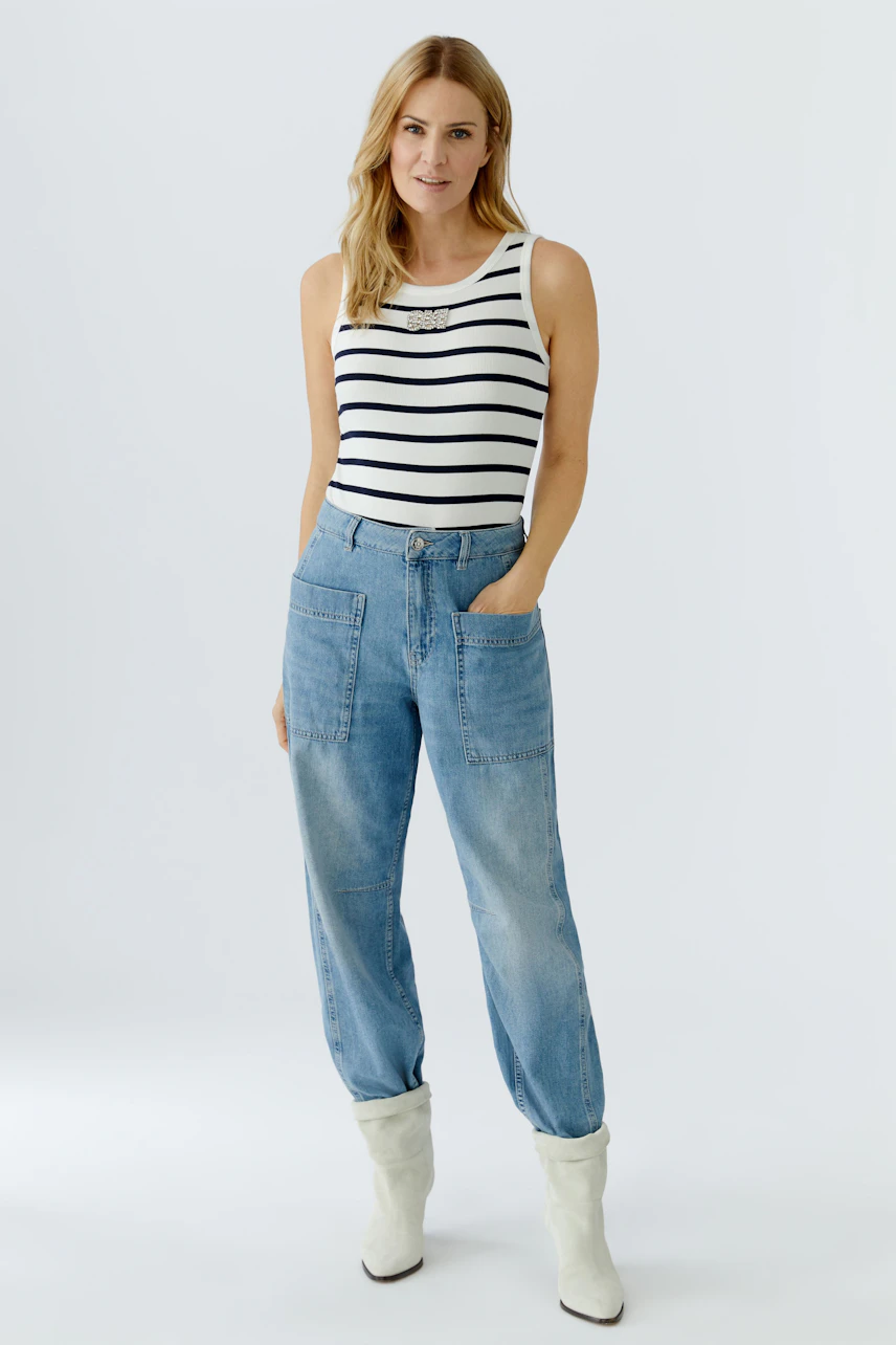 Casual women's tank top: Woman in a striped tank top paired with relaxed-fit jeans.
