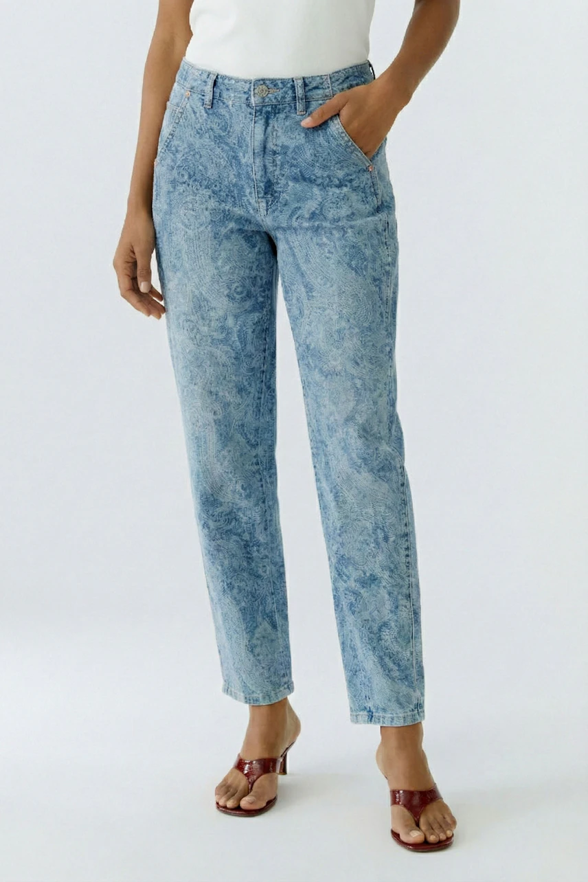 Bequeme Damen-Jeans: Frau in lässigen, hellblauen Relaxed Jeans mit Paisleymuster und Sandalen.