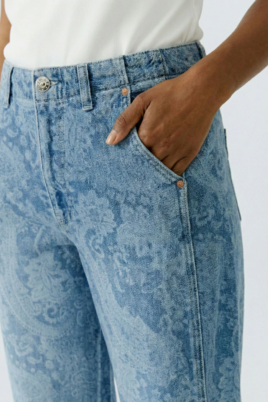Bequeme Damen-Jeans: Frau trägt lässige, hellblaue Jeans mit floralem Muster und seitlichen Taschen.