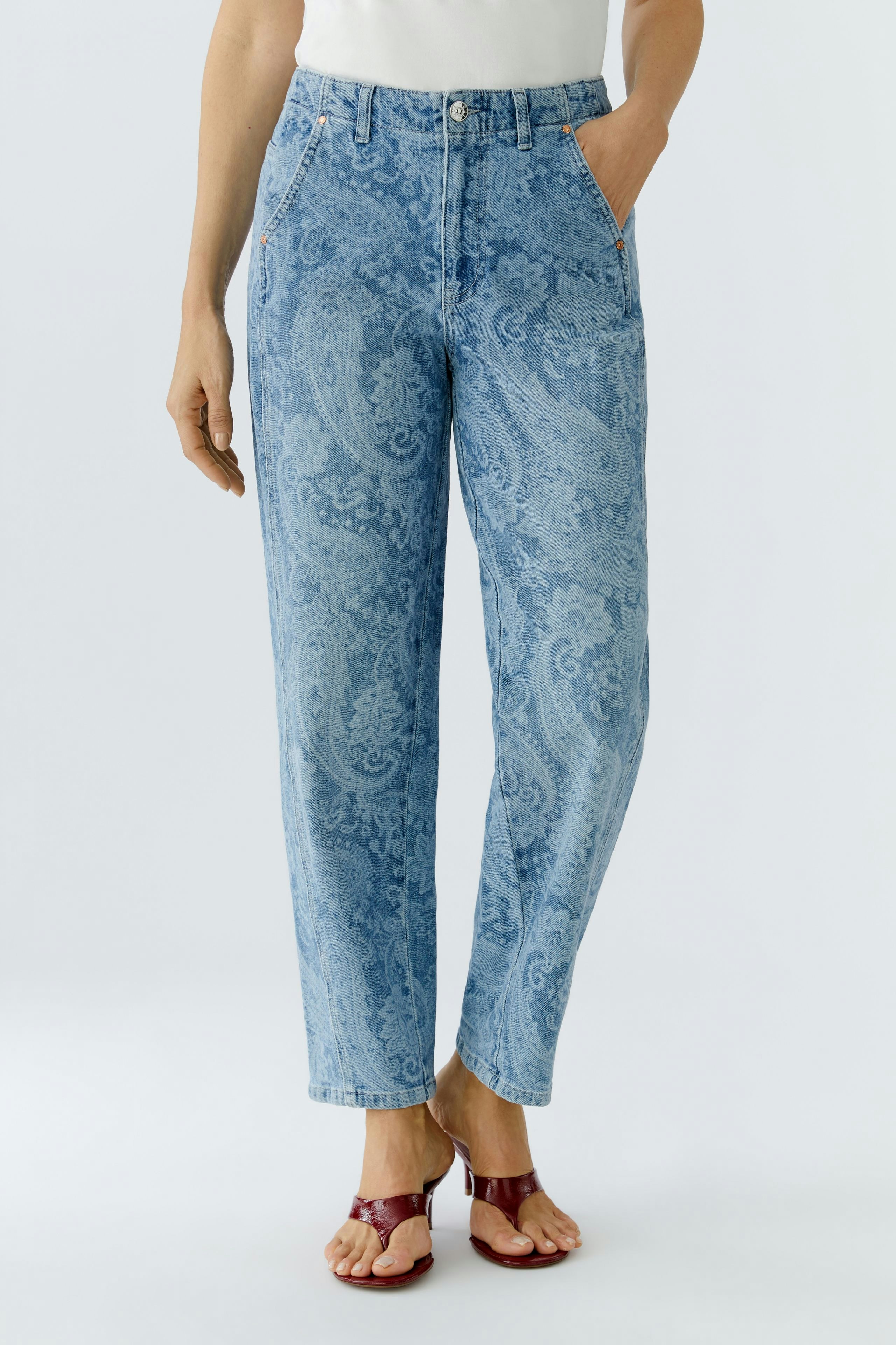 Bequeme Damen-Jeans Relaxed: Frau in hellblauen Jeans mit Paisleymuster und lässigen Sandalen.