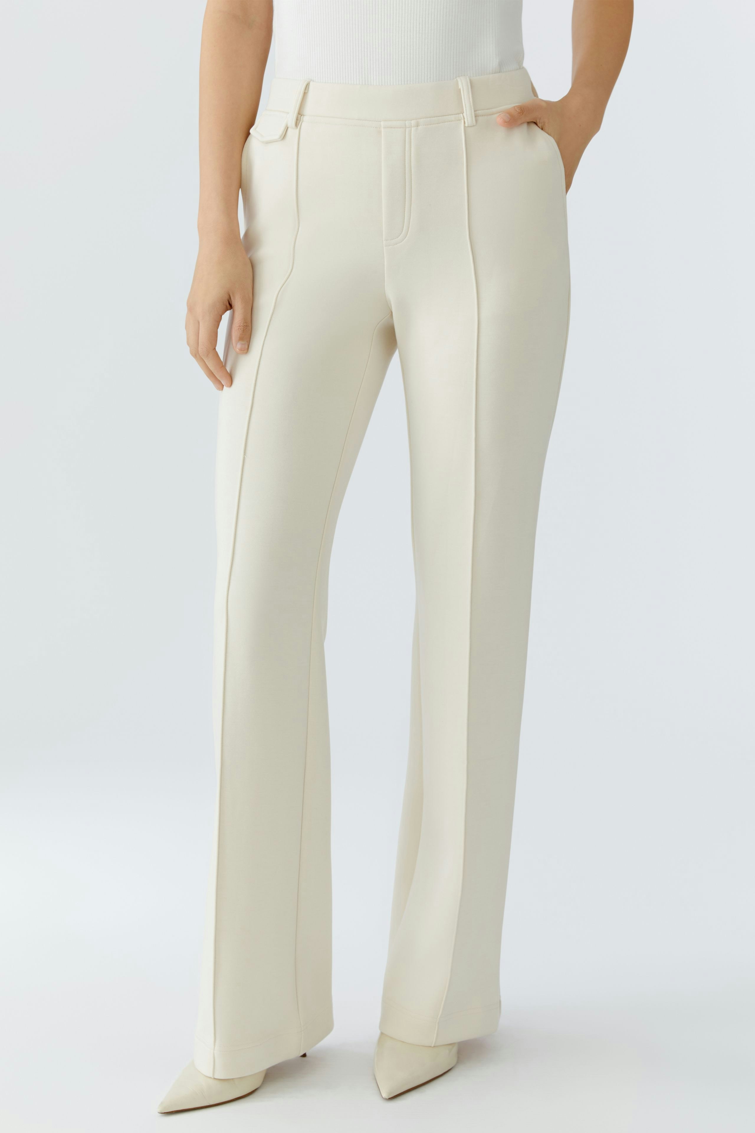 Chic women's trousers: A woman in cream-colored trousers with a tailored fit, perfect for casual outings.