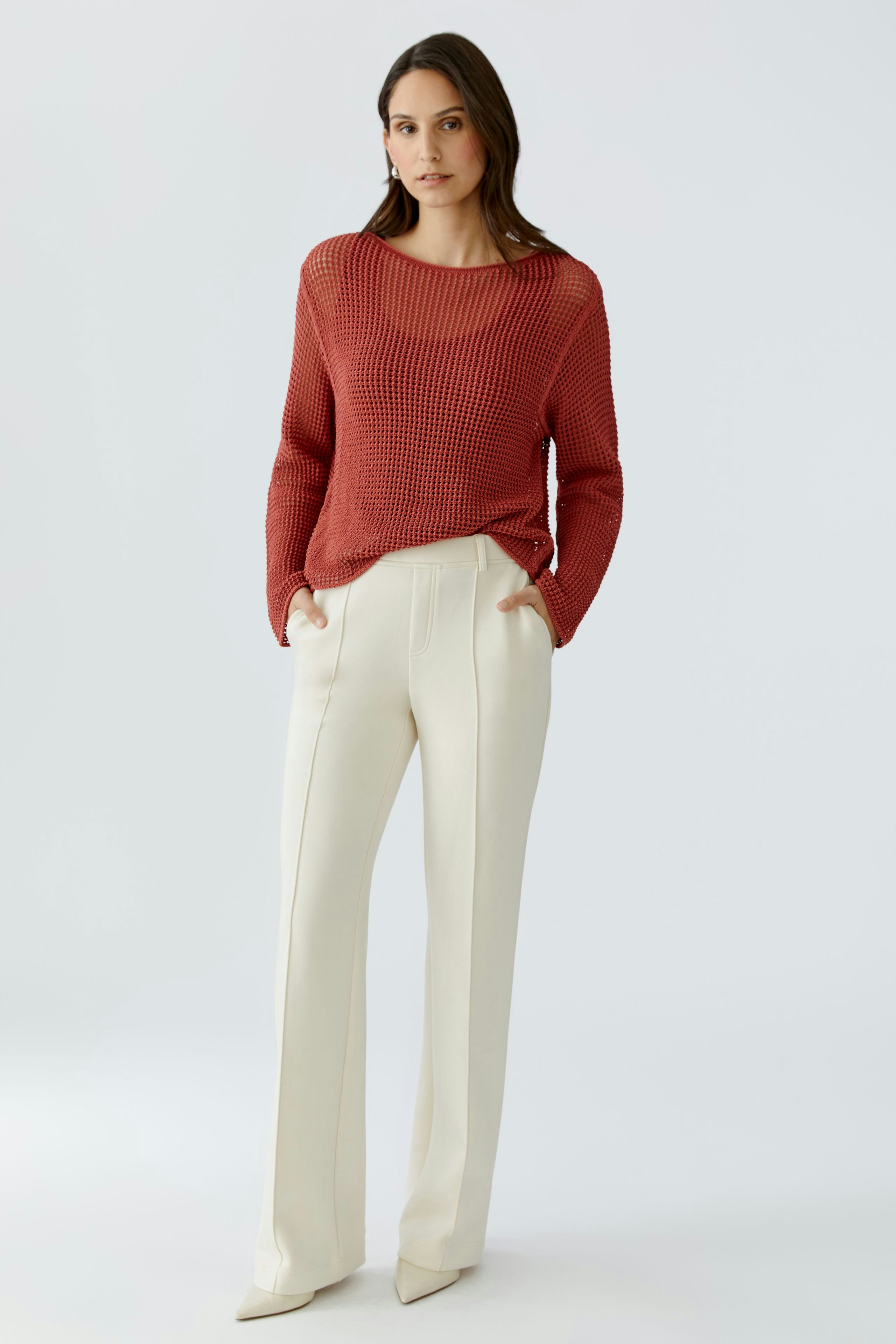Casual women's pants: A woman in cream-colored trousers with a relaxed fit and side pockets.