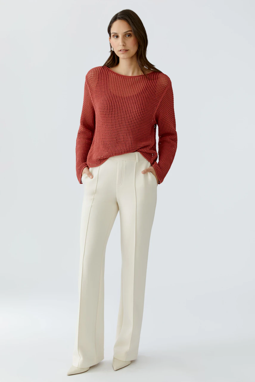 Casual women's pants: A woman in cream-colored trousers with a relaxed fit and side pockets.