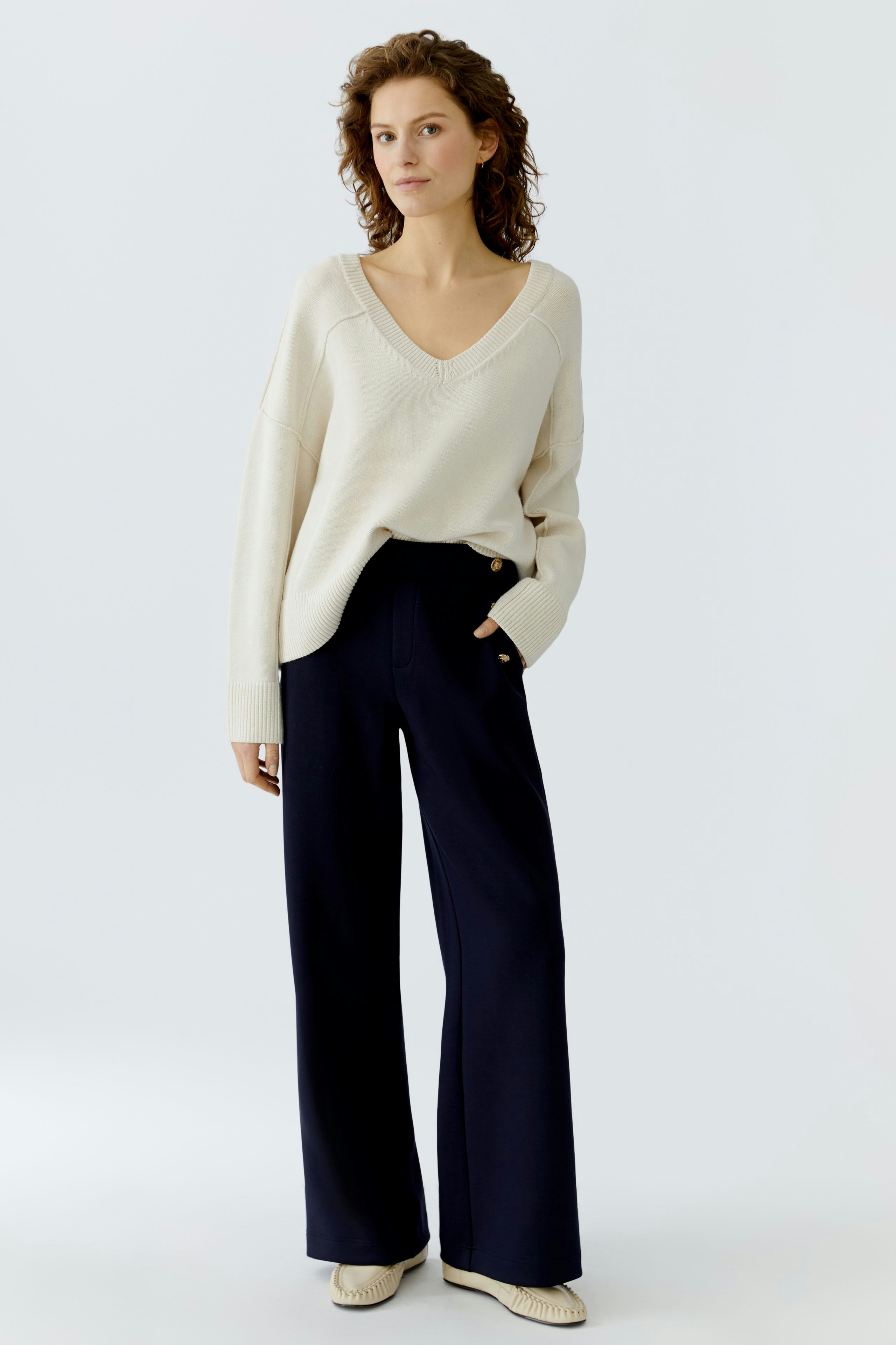 Casual women's pants: A woman in wide-leg navy trousers paired with a light pullover.