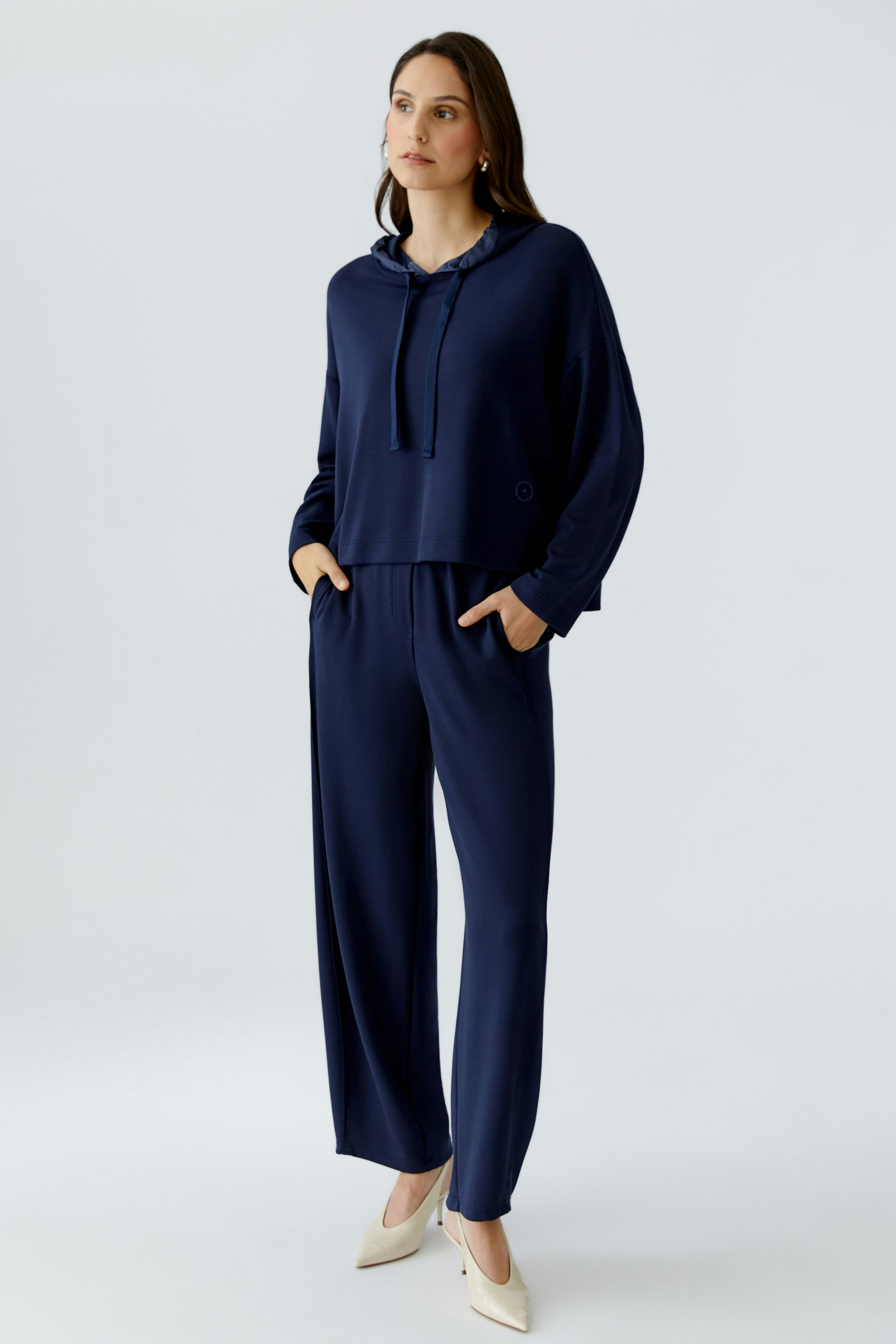Casual women's sweatpants: A woman in navy sweatpants and matching hoodie stands confidently.
