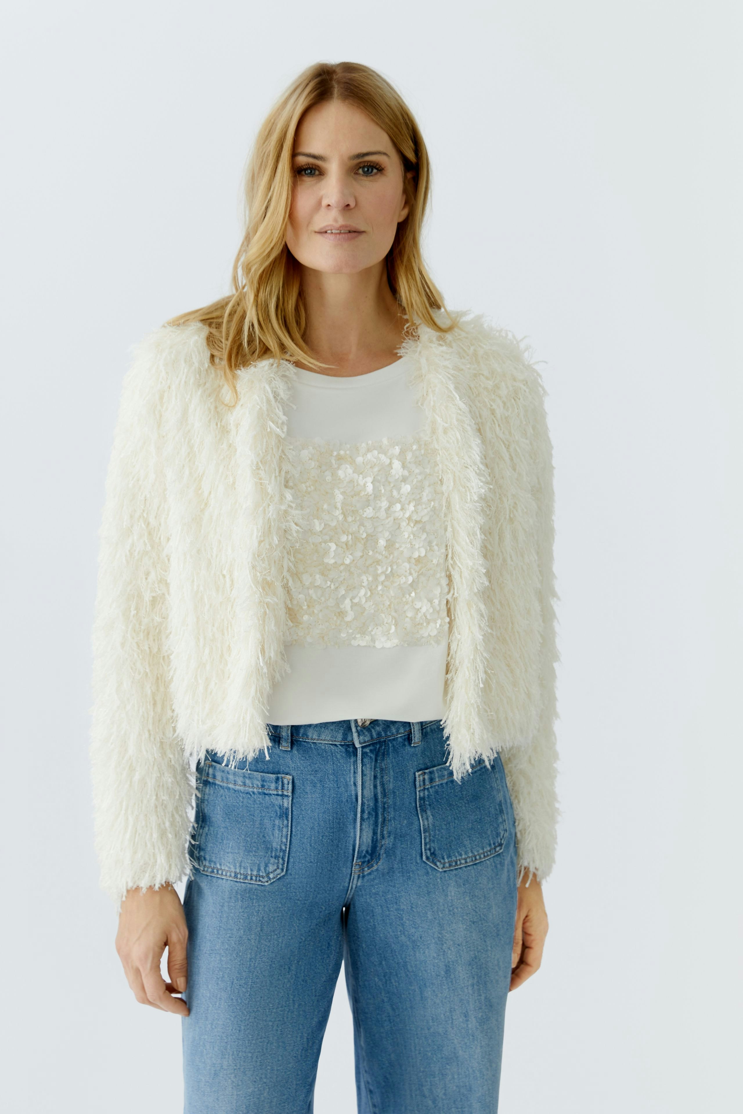 Fluffy white women's jacket paired with a simple top and jeans, showcasing a casual style.