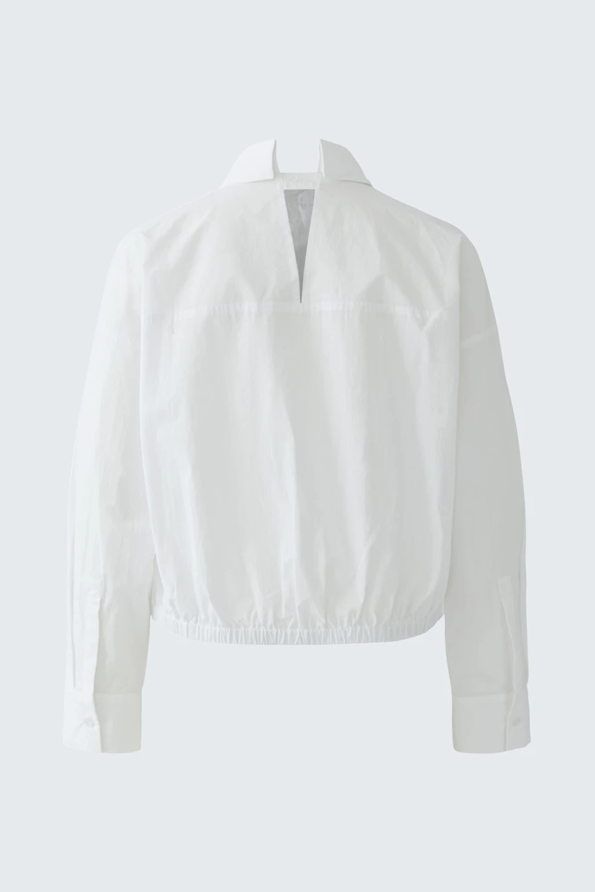 Casual women's blouse: White, cropped design with a back opening and long sleeves.