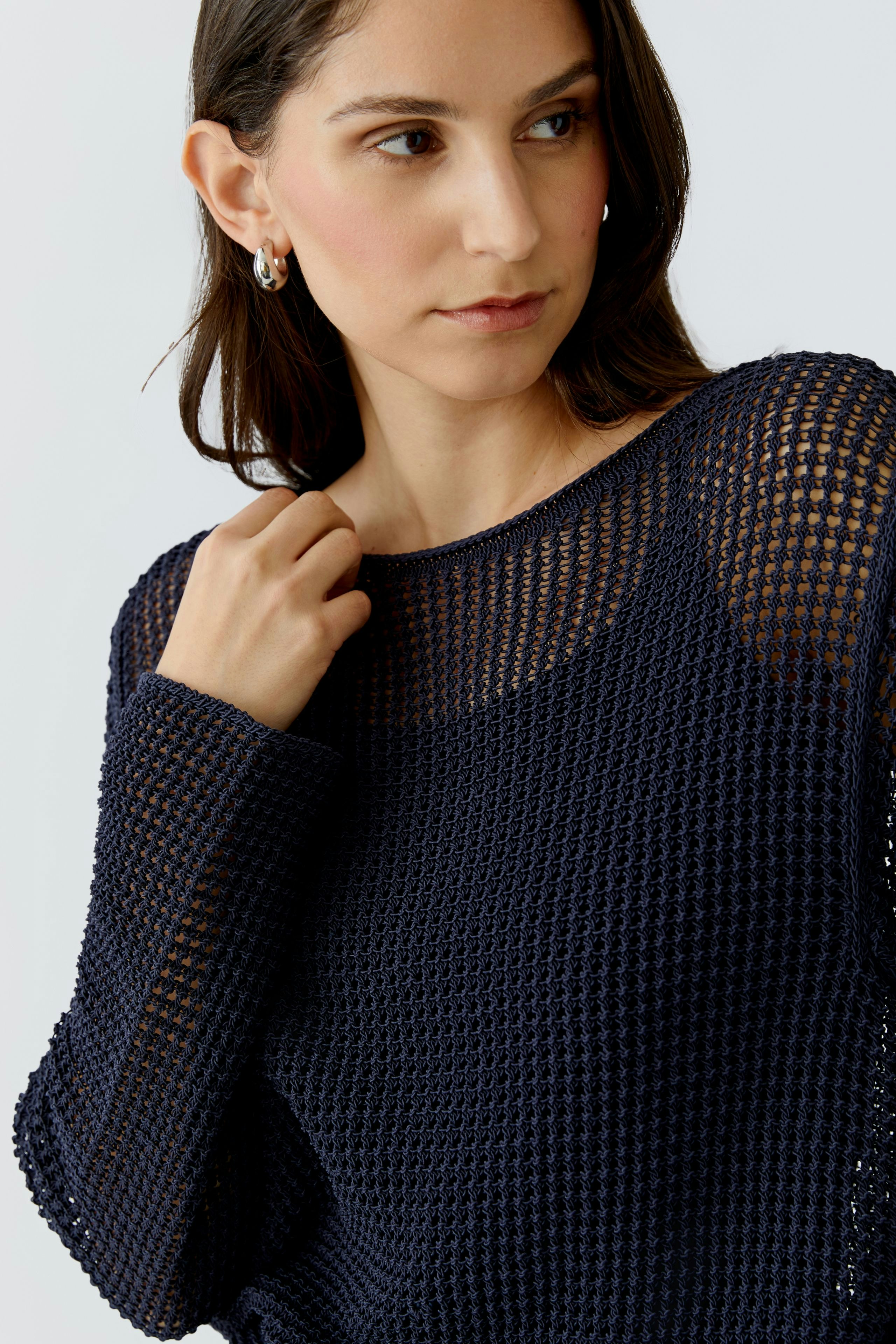 Modern women's pullover: A woman in a navy knitted pullover with a relaxed fit.