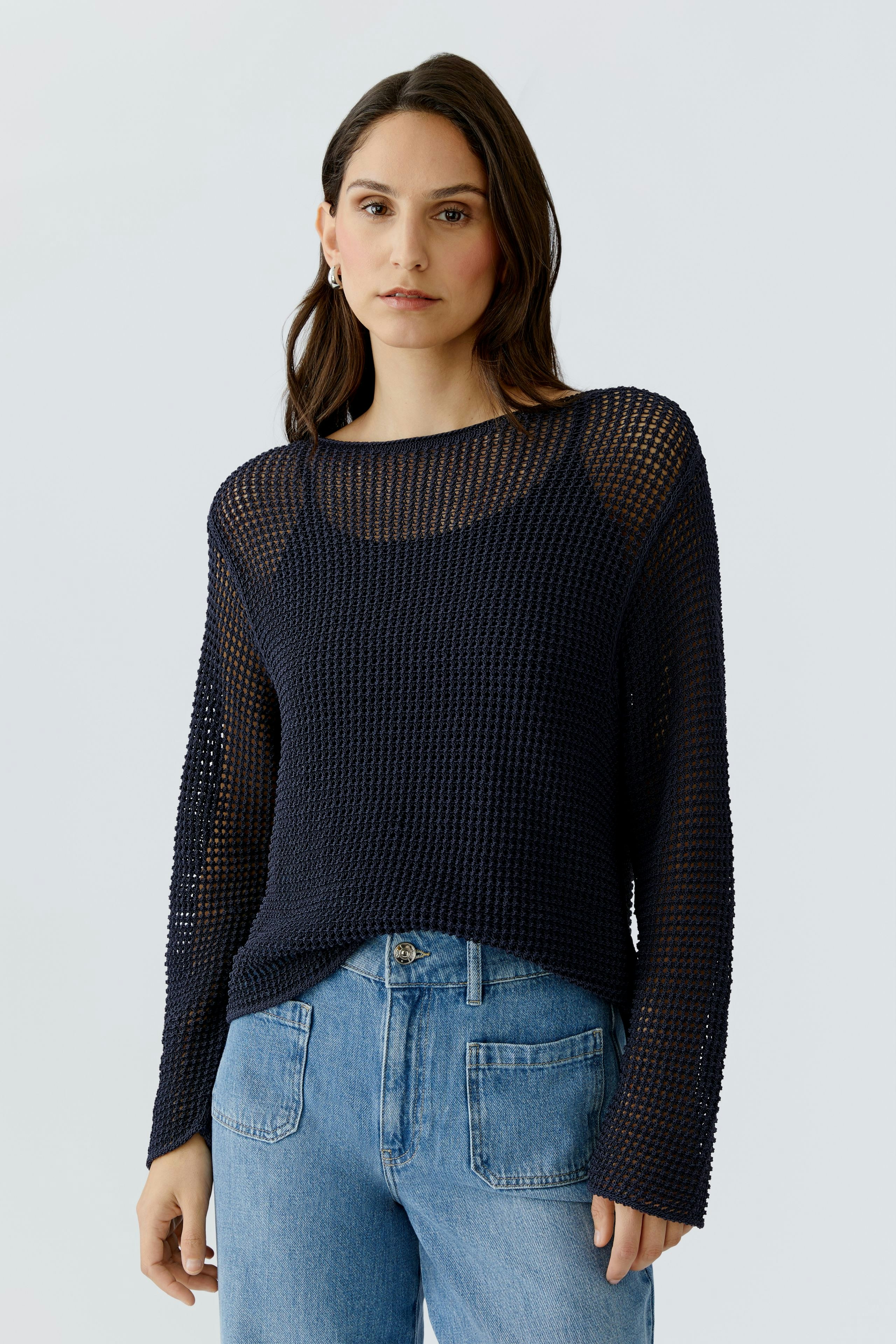 Casual women's pullover: A woman in a navy knitted pullover with a relaxed fit and long sleeves.