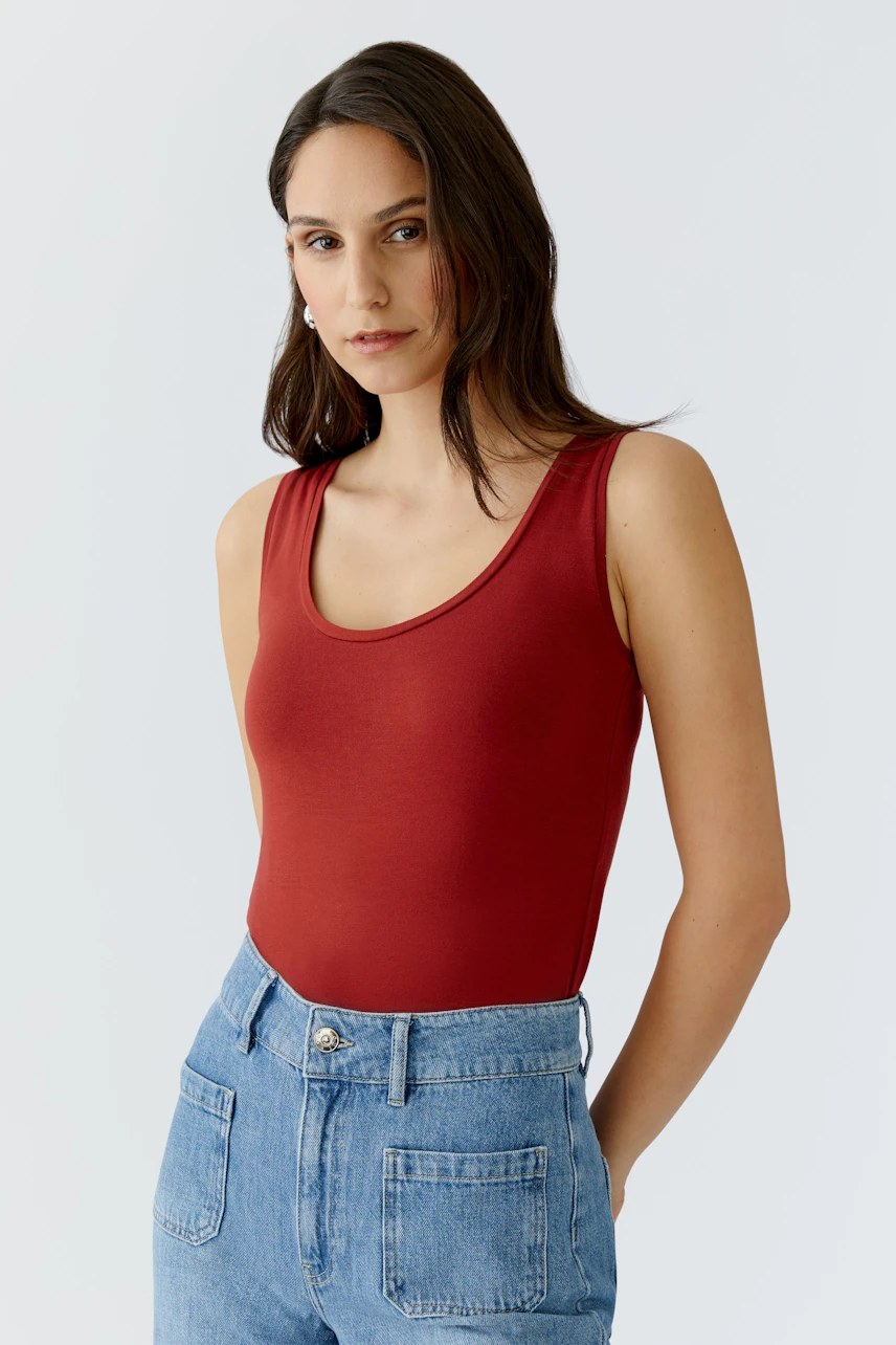 Damen Tank Top in Rot: Frau trägt ein schlichtes, ärmelloses Oberteil mit Rundhalsausschnitt.