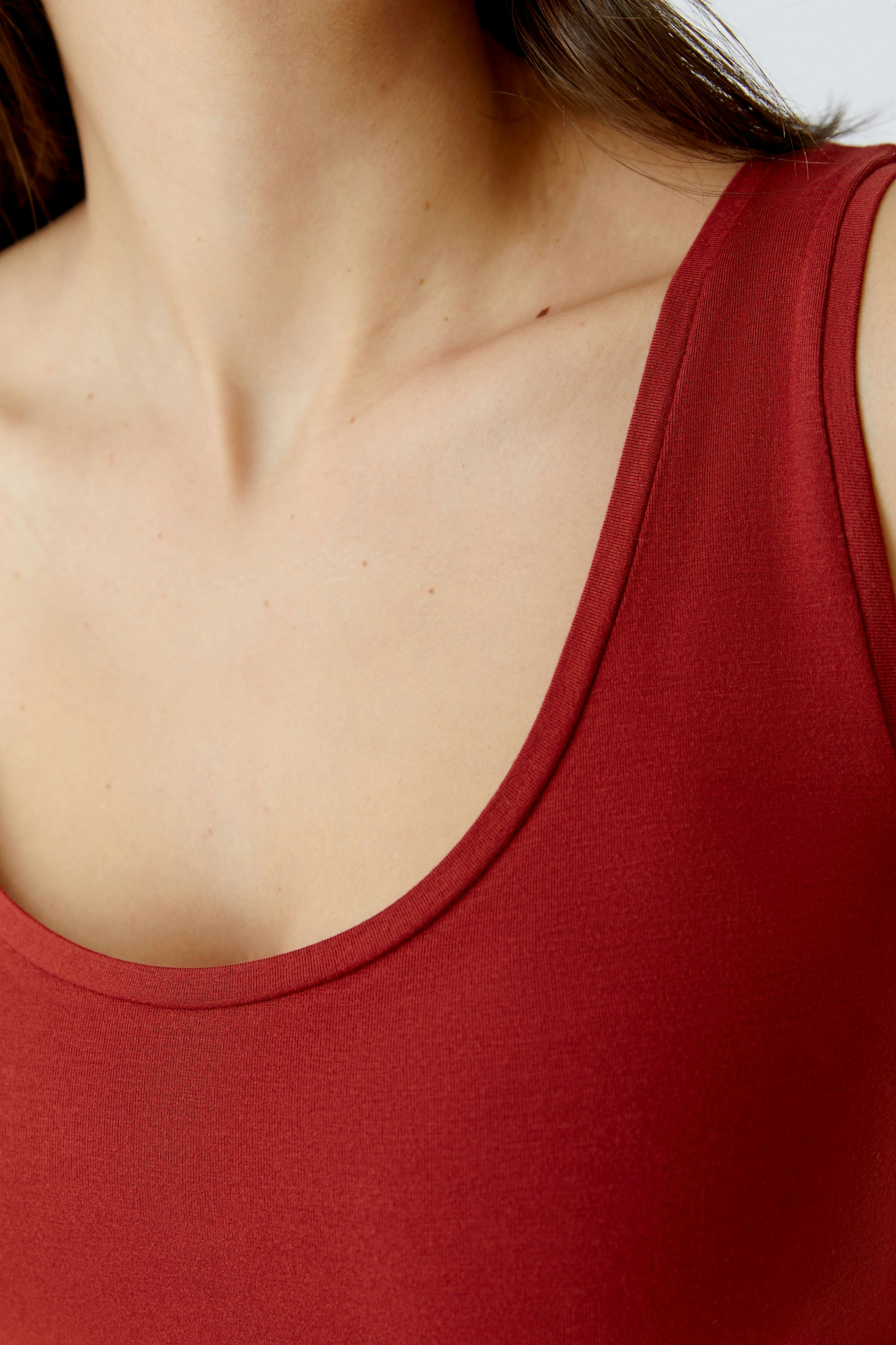 Casual women's tank top in a rich red color, featuring a scoop neckline and a comfortable fit.