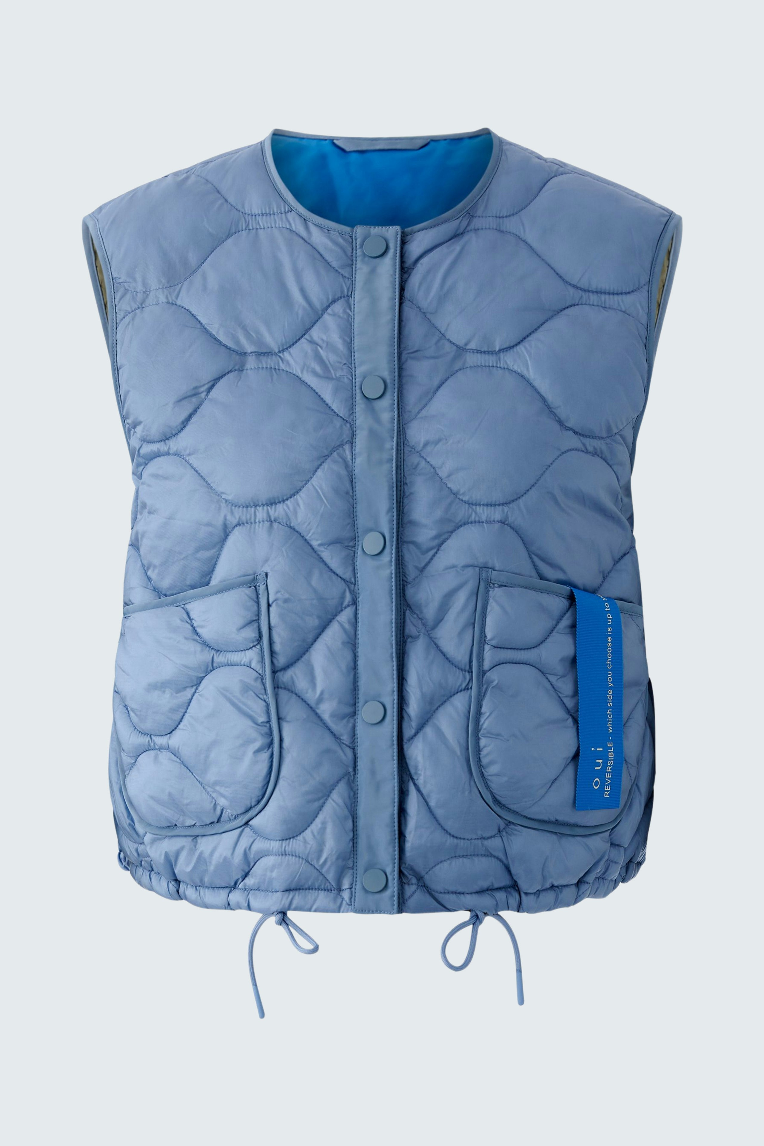 Reversible jacket: A woman in a light blue quilted vest with pockets, perfect for layering.