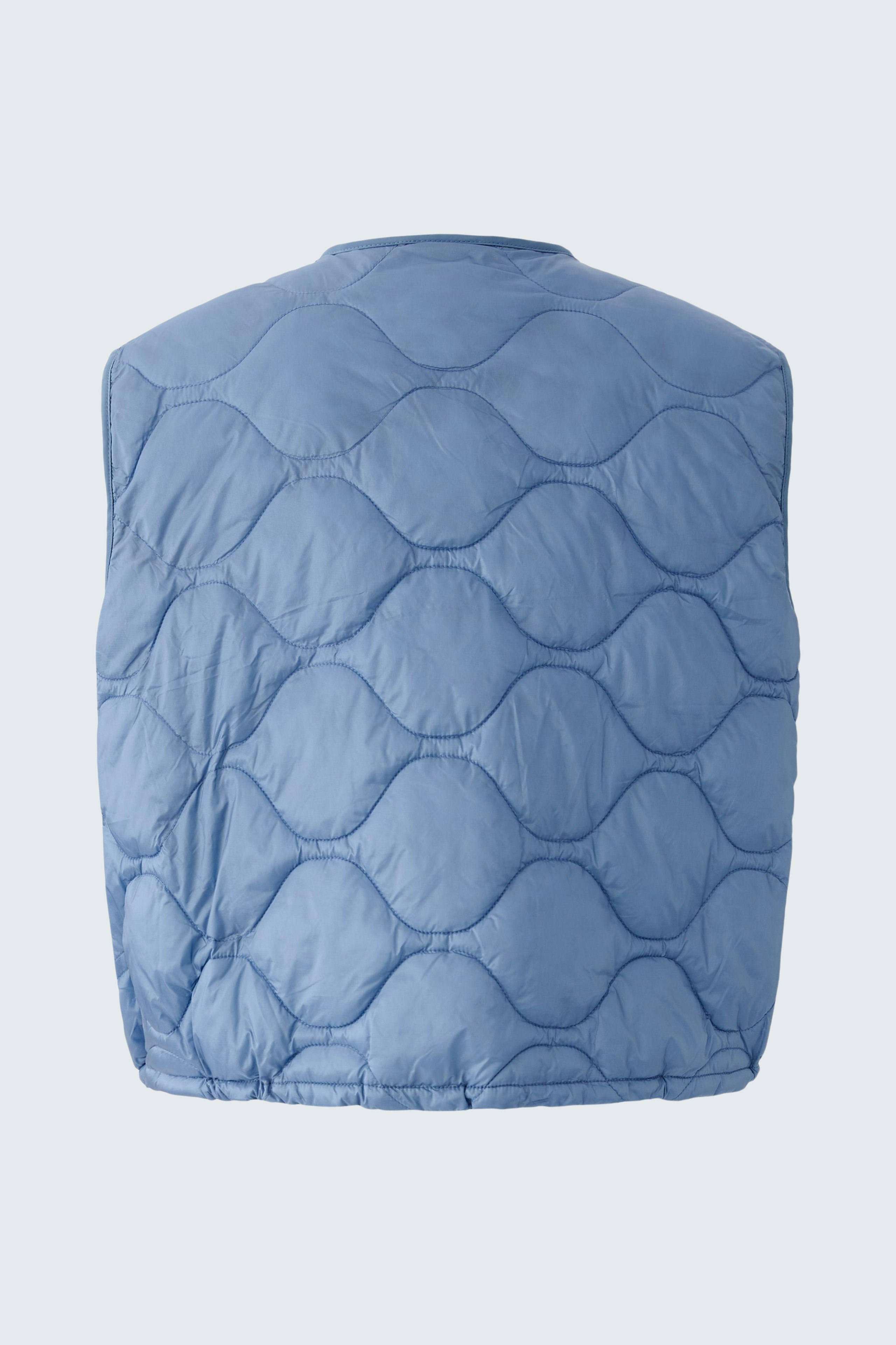 Reversible jacket: A woman in a light blue quilted reversible jacket, perfect for layering.