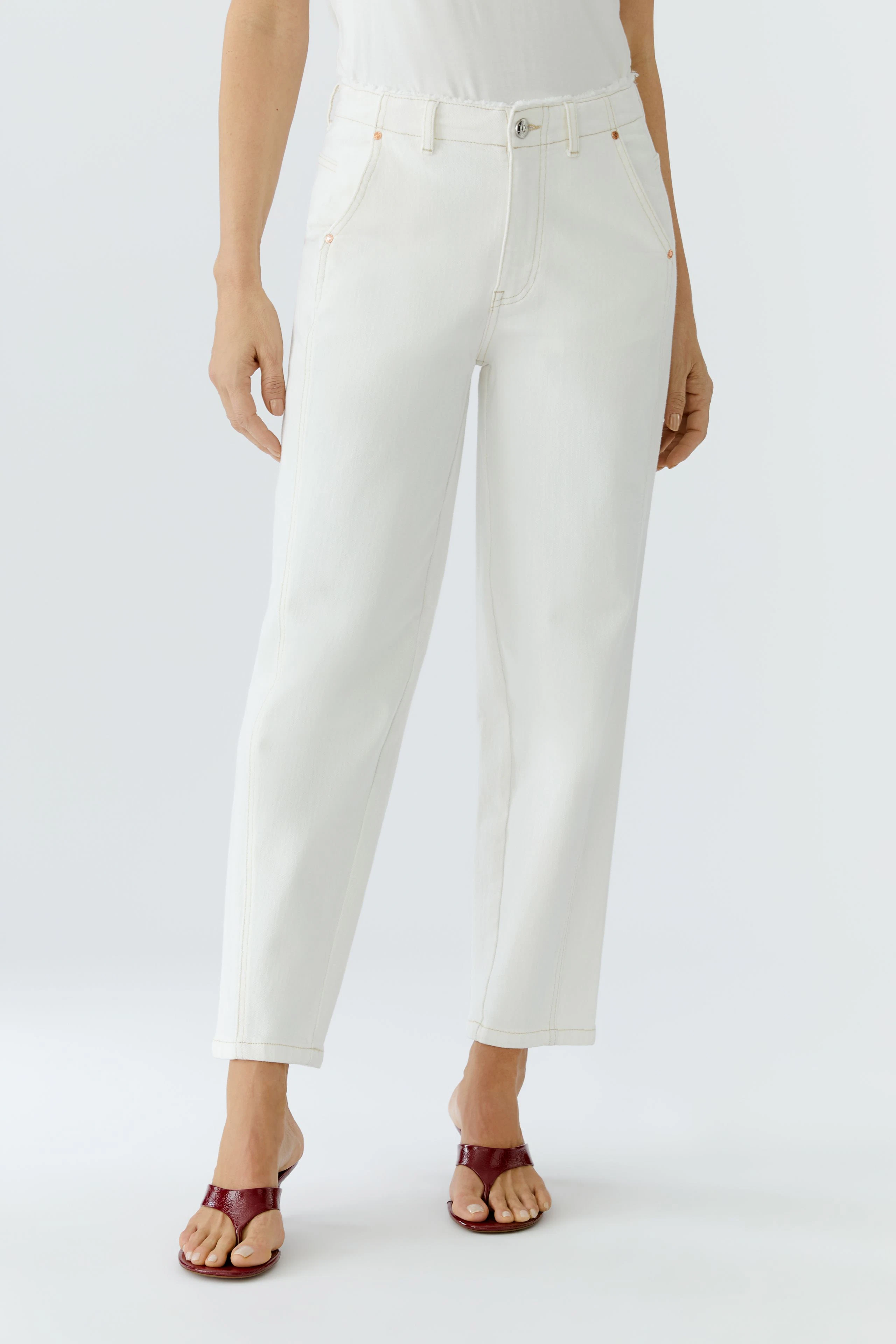 Bequeme Damen-Jeans: Frau in weißen Relaxed Jeans mit lässigem Schnitt und Sandalen.