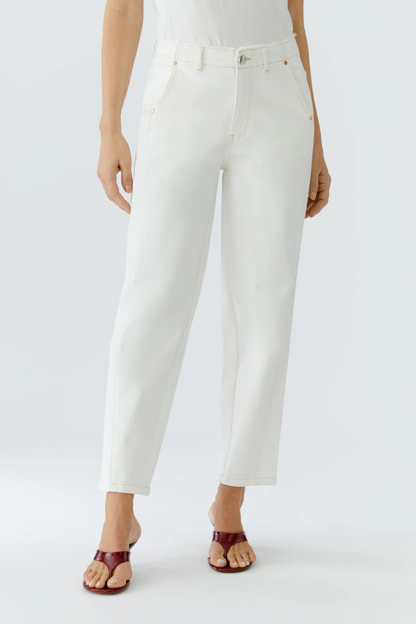 Relaxed fit women's jeans in white, paired with stylish sandals, showcasing a casual look.
