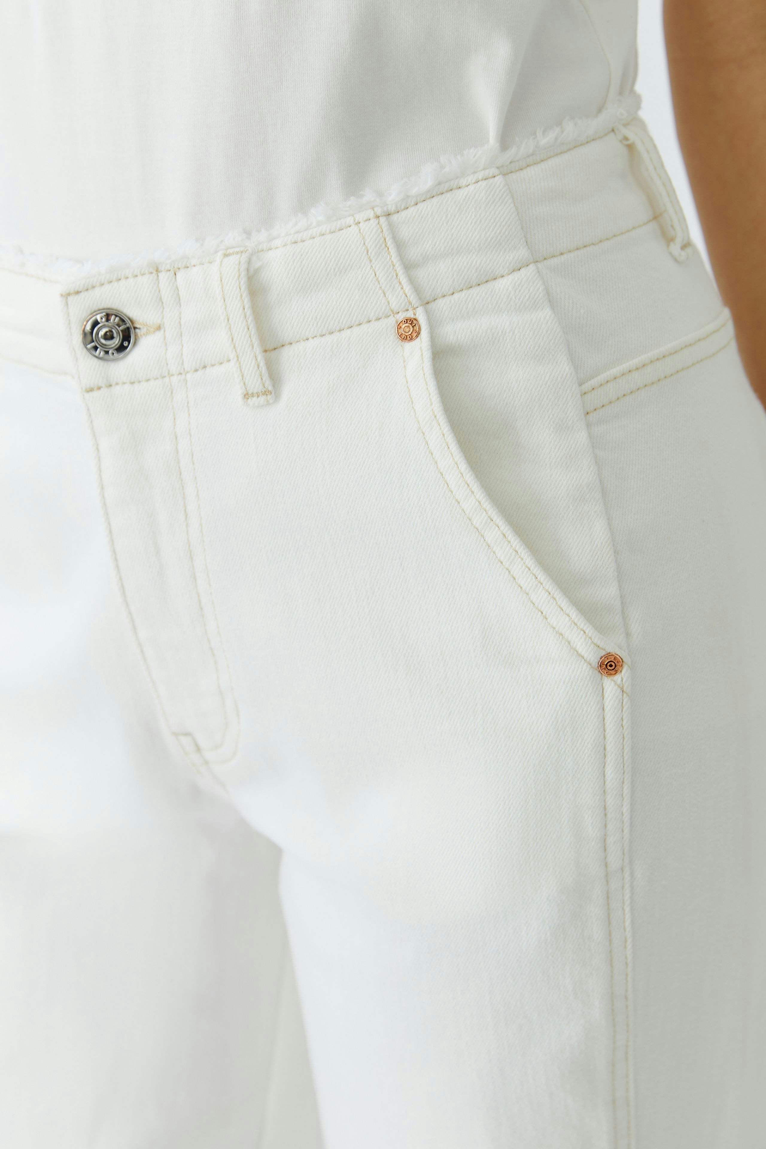 Relaxed fit women's jeans: Close-up of white jeans with classic pockets and subtle stitching details.