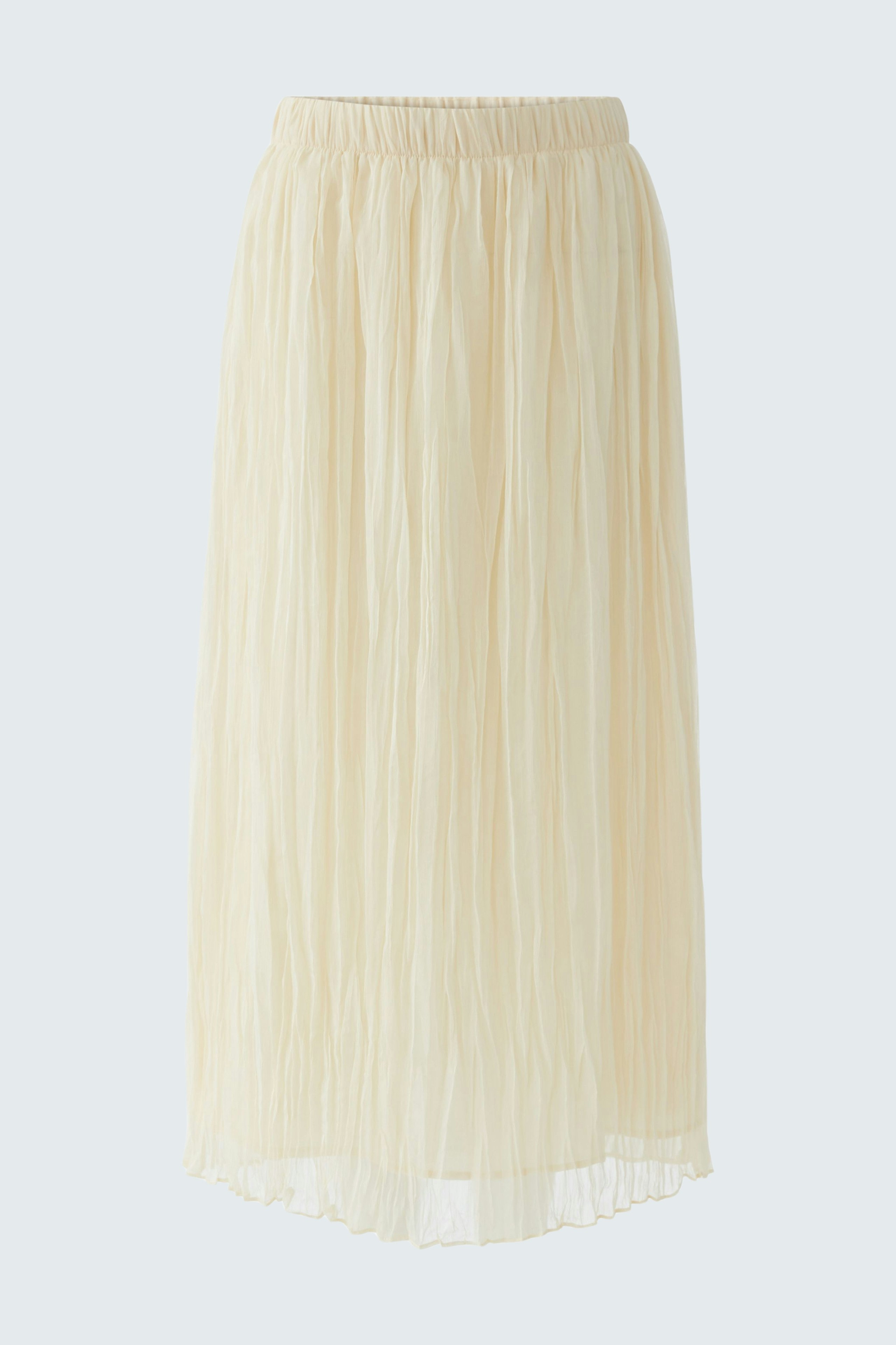 Light pleated skirt: A woman in a flowing, cream-colored pleated skirt, perfect for casual wear.