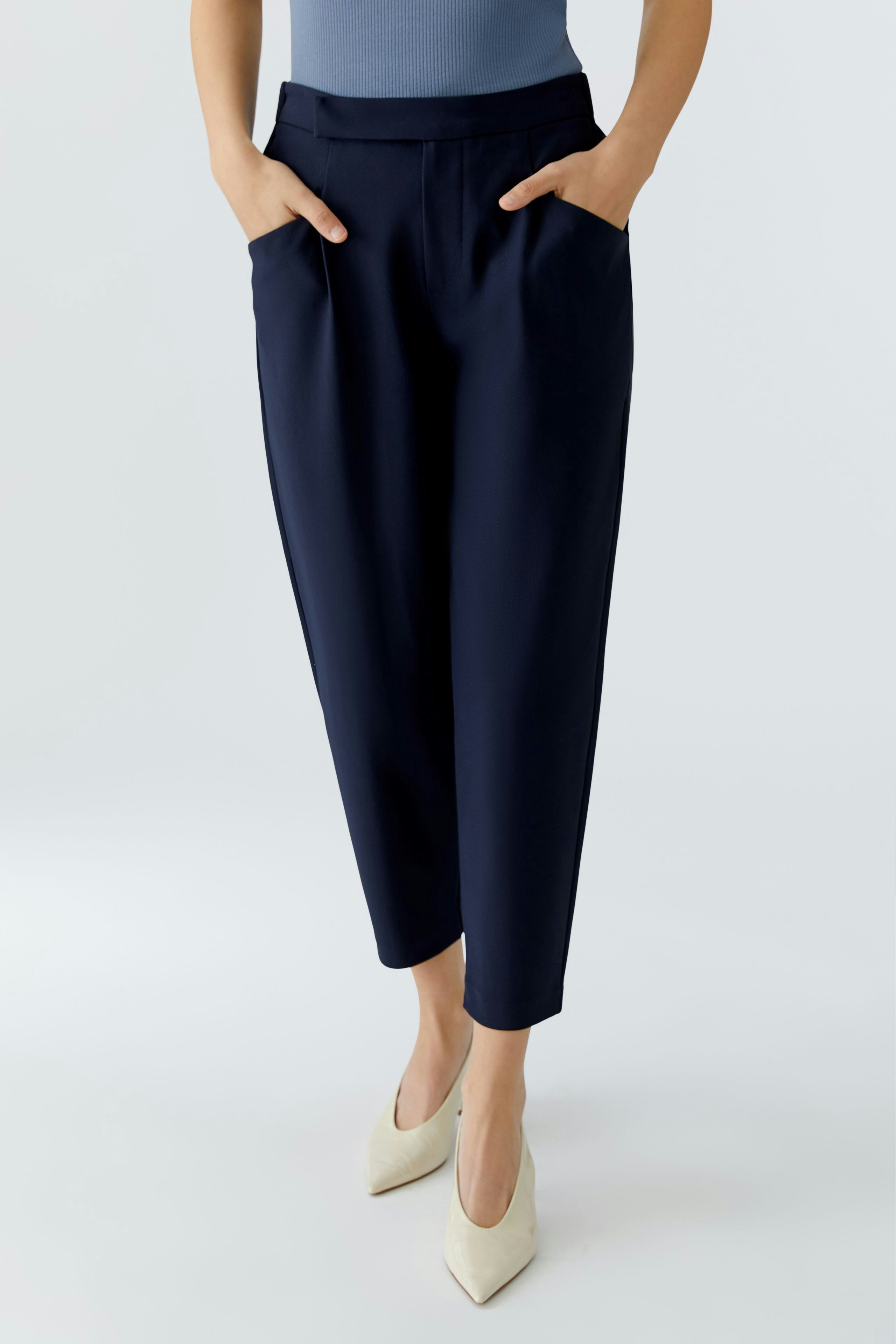 Casual women's trousers: A woman in navy pants with pockets, paired with a fitted top.