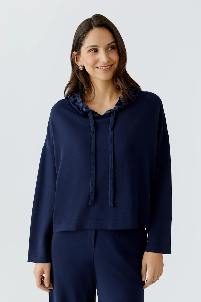 Damen-Hoodie: Frau in navyblauem, lässigem Hoodie mit Kapuze und Kordelzug, entspannt und modisch.