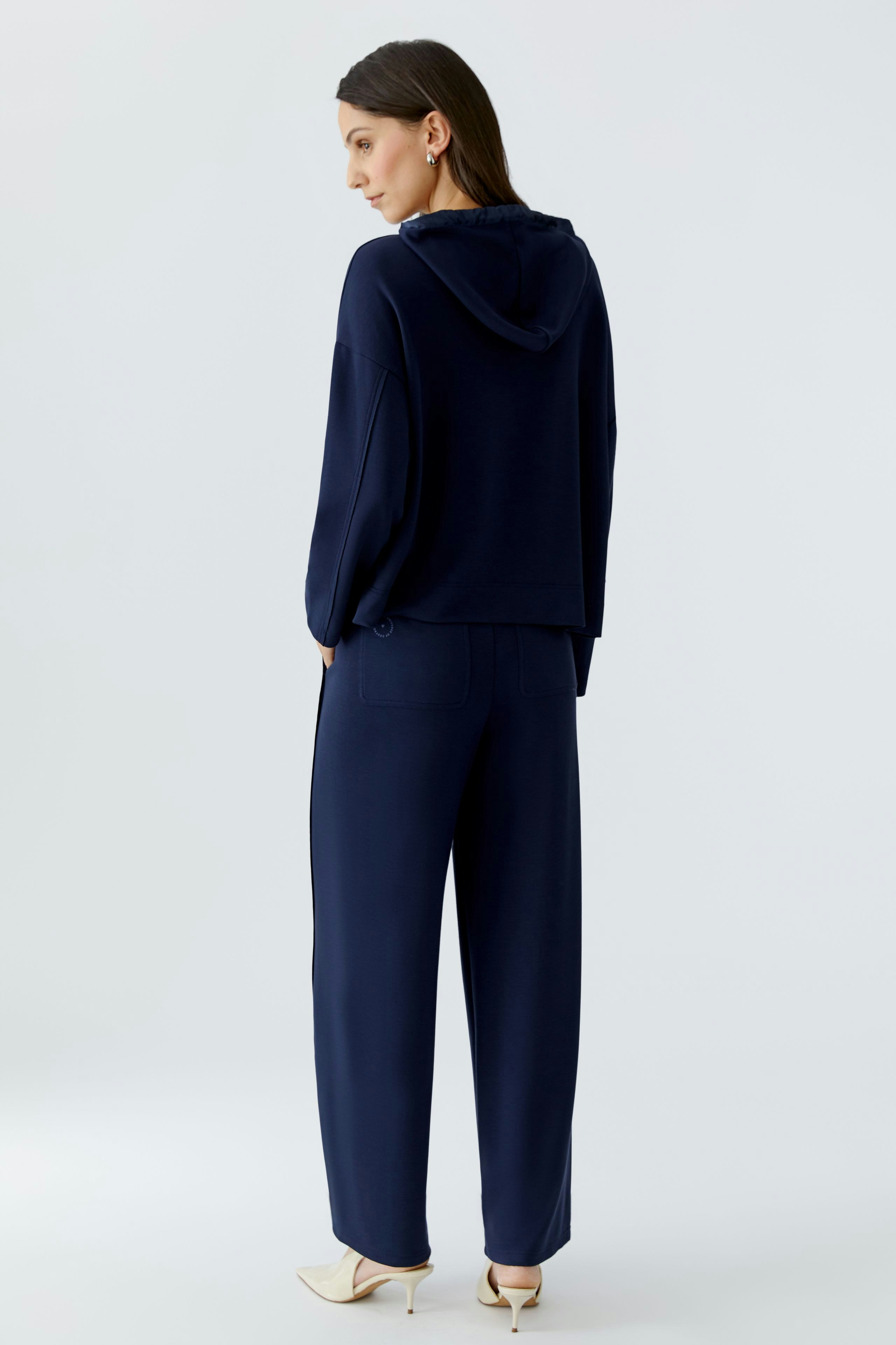 Casual women's hoodie: A woman in a navy pullover with a hood and relaxed fit, paired with matching pants.