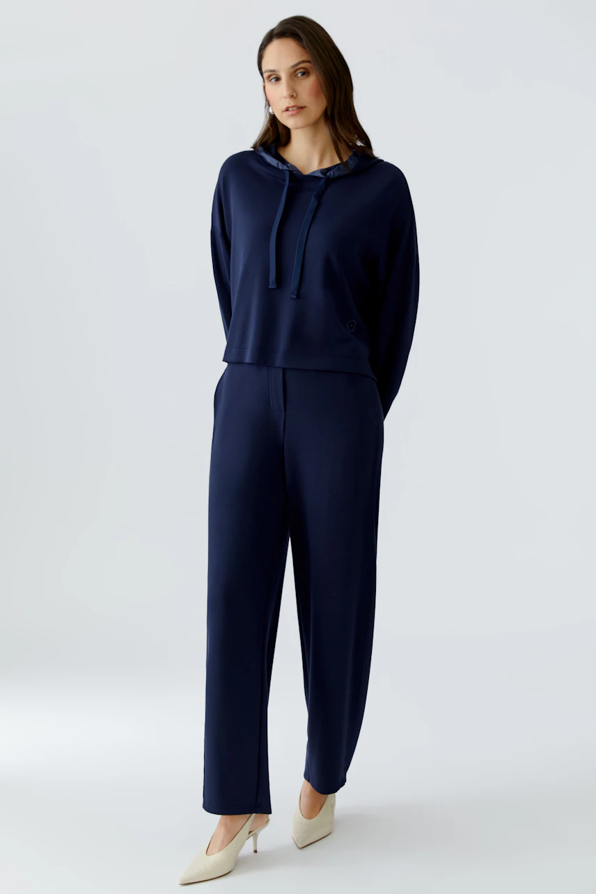 Bequemer Damen-Hoodie: Frau in navyblauem Hoodie mit Kordelzug und lässiger Passform.