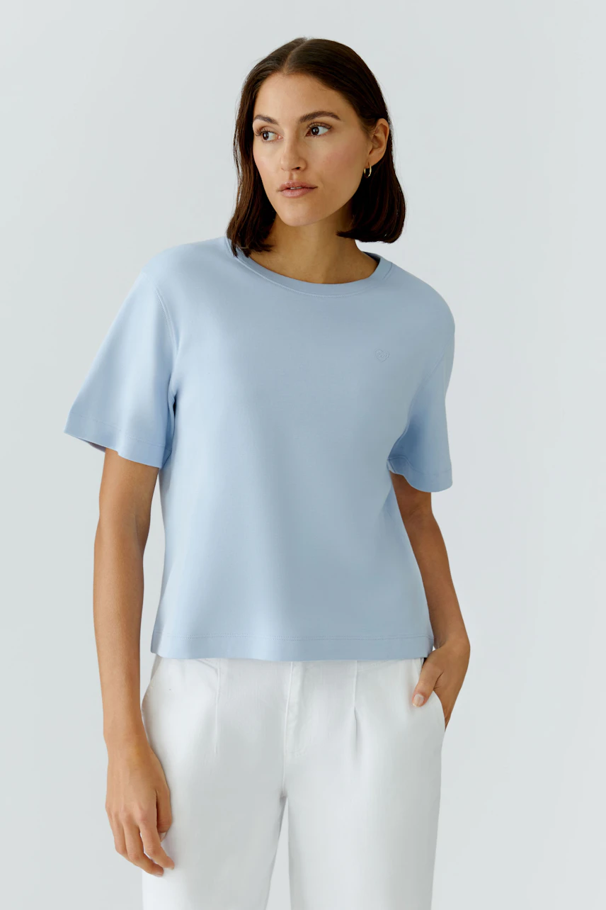 Bequemes Damen-T-Shirt in Hellblau: Frau trägt lässiges Shirt mit kurzen Ärmeln und Rundhalsausschnitt.