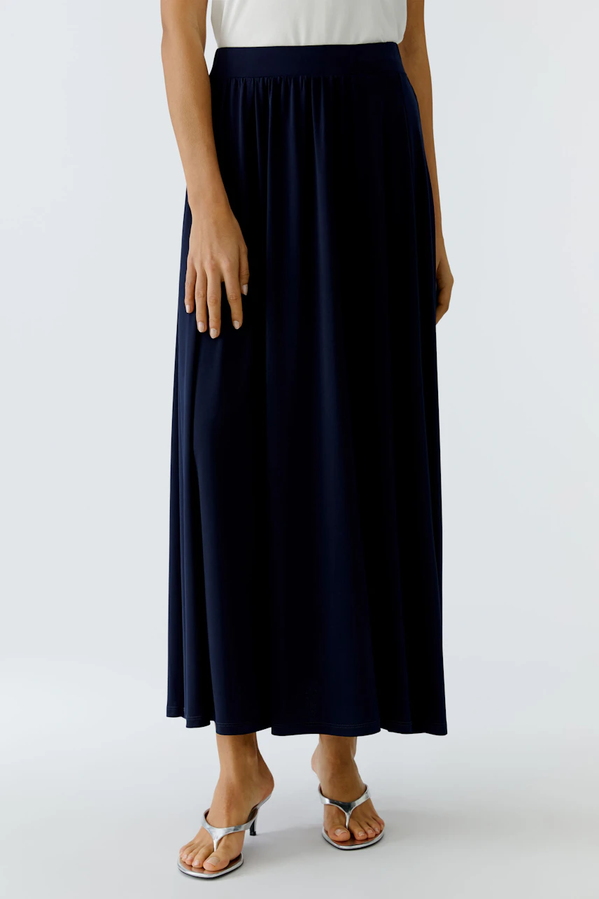 Casual A-line skirt: Woman in a flowing navy skirt paired with a simple top, showcasing a relaxed style.