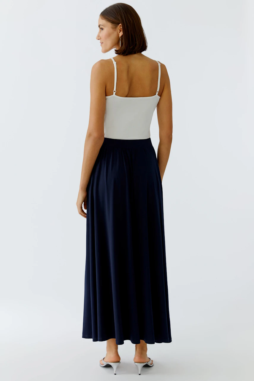 A-line skirt: Woman in a navy skirt with a flowing design, paired with a simple white top.