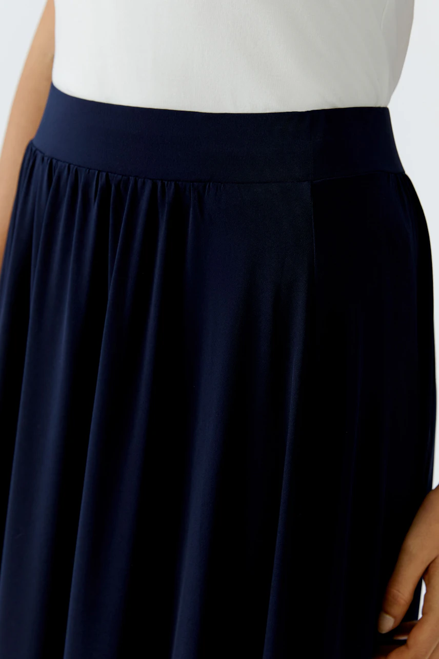 A-line skirt: Woman wearing a navy skirt with a comfortable waistband, perfect for casual outings.